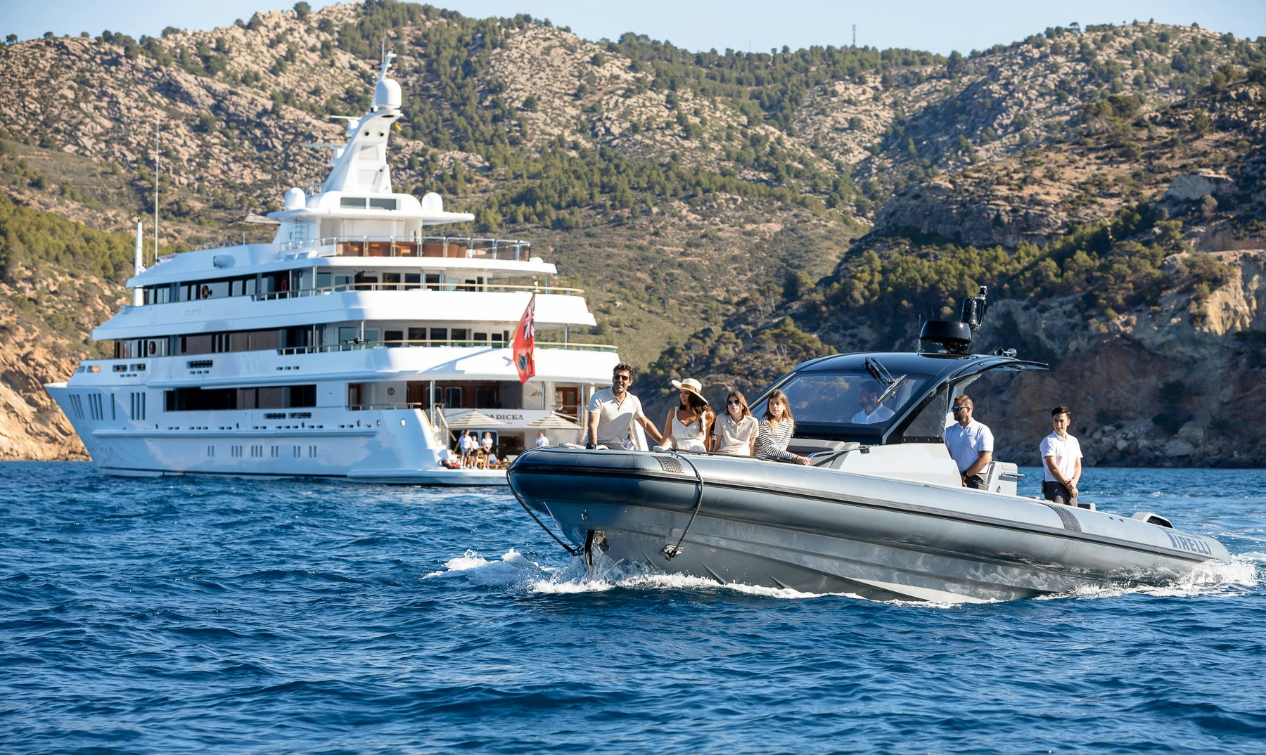 a group of people on a boat in the water by a boat aboard BOADICEA Yacht for Charter
