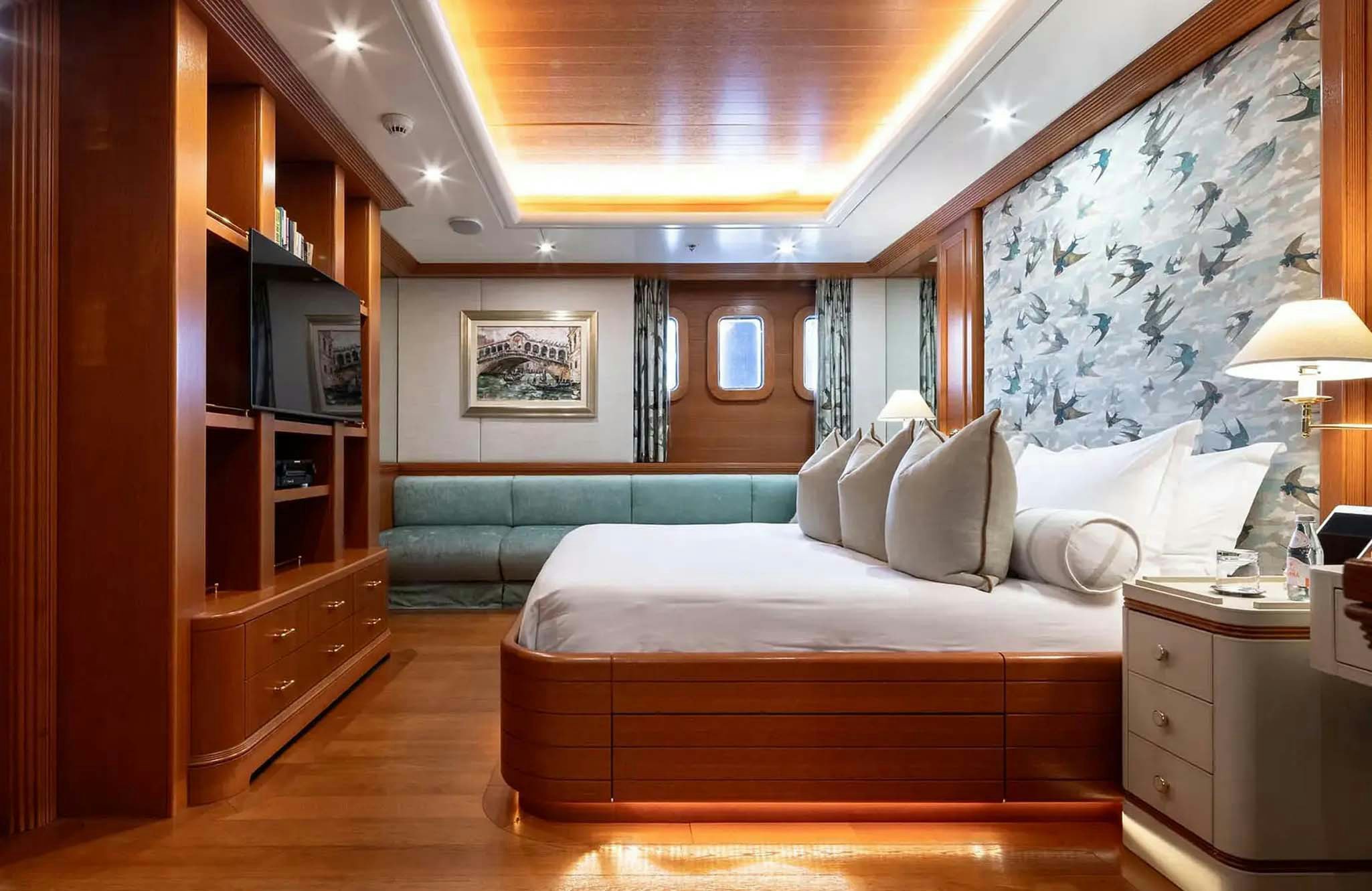 a bedroom with a bed and a tv aboard BOADICEA Yacht for Charter