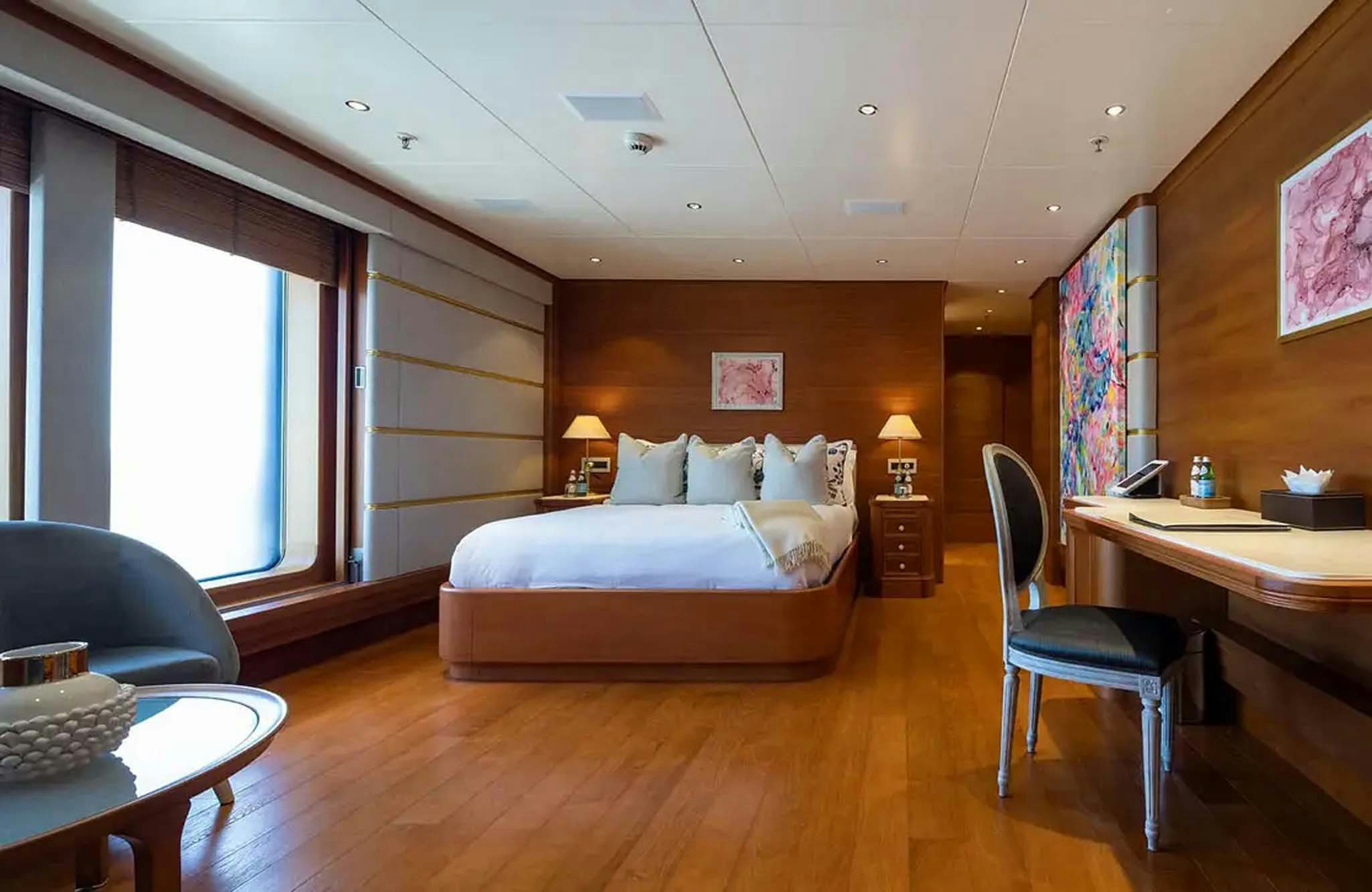 a bedroom with a bed and a desk aboard BOADICEA Yacht for Charter