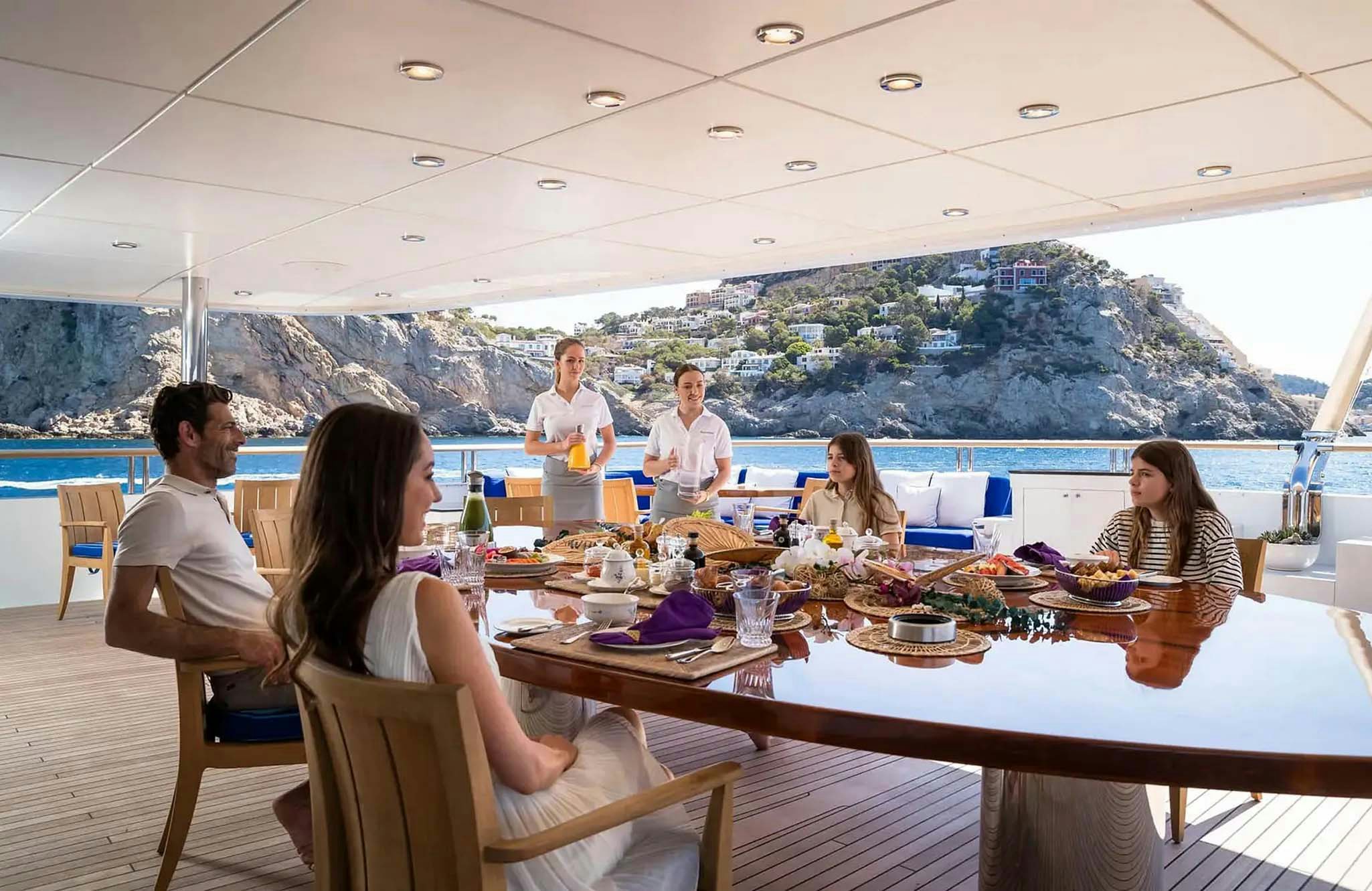 a group of people sitting around a table with food on it aboard BOADICEA Yacht for Charter