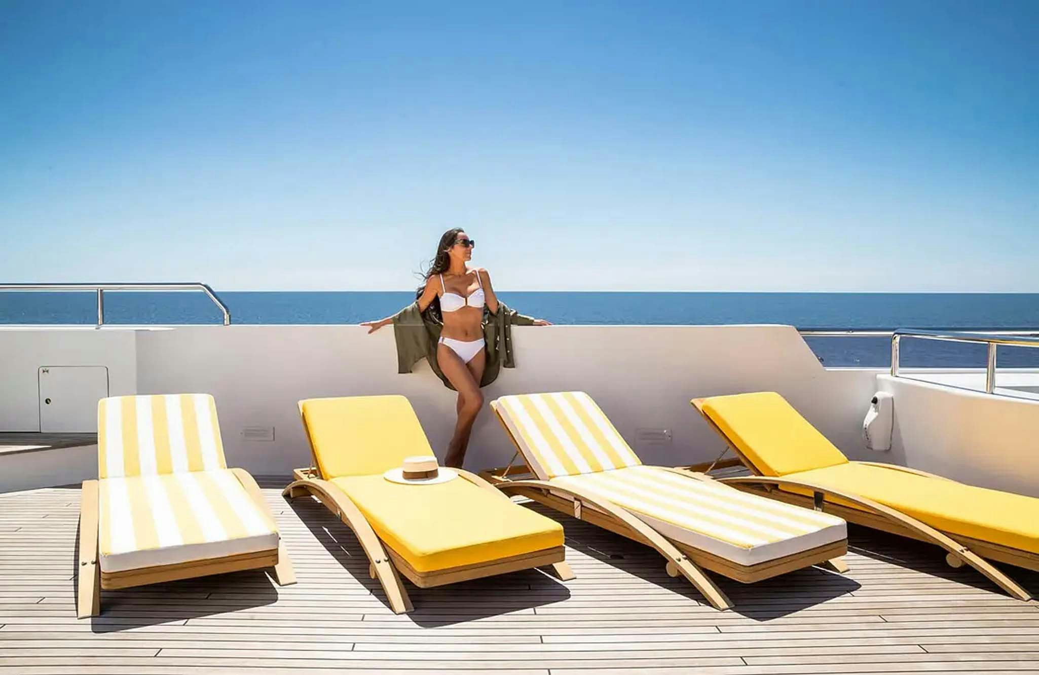 a person standing on a lounge chair on a boat aboard BOADICEA Yacht for Charter