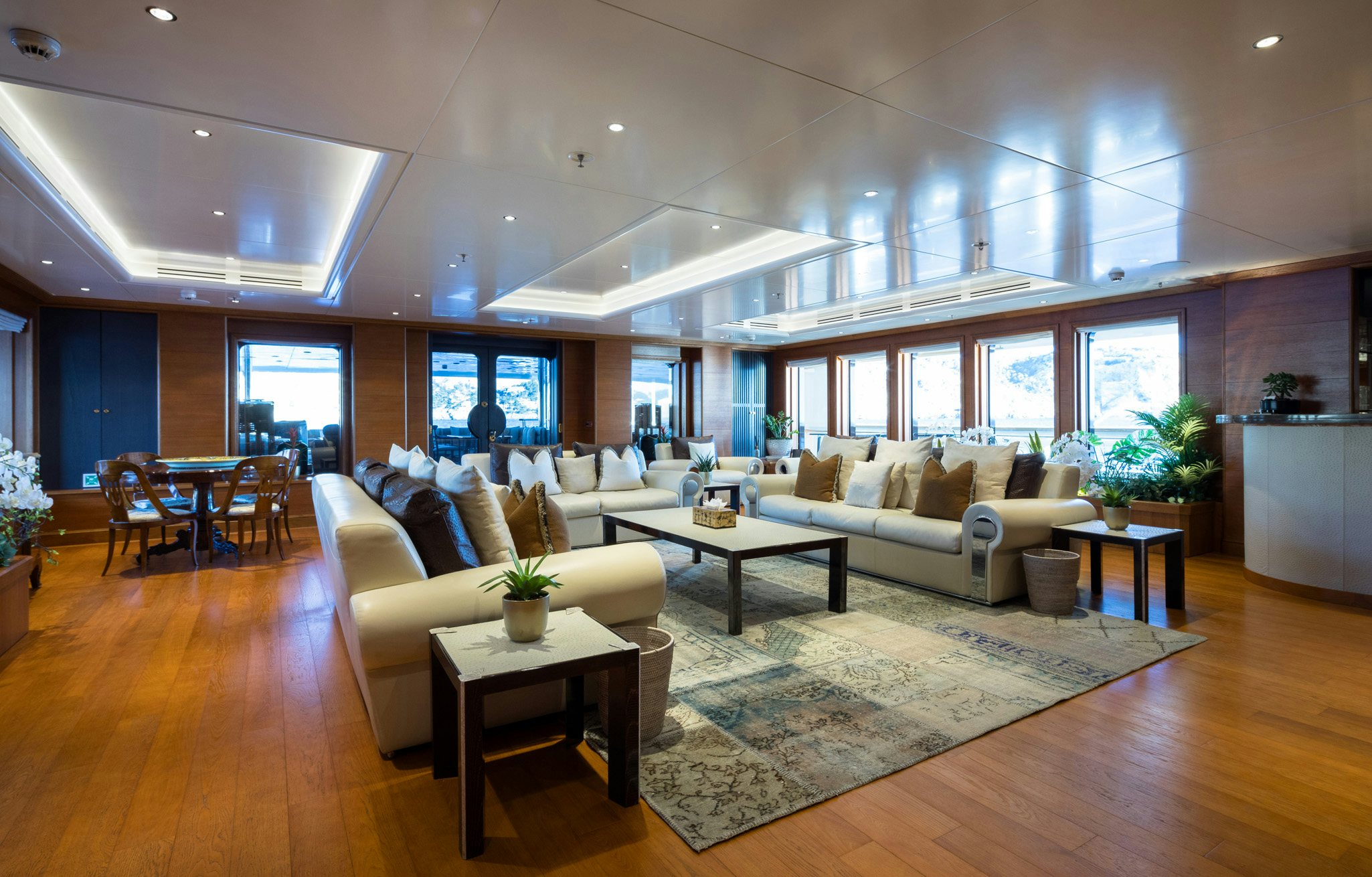 a living room with a large white sofa and a table aboard BOADICEA Yacht for Charter