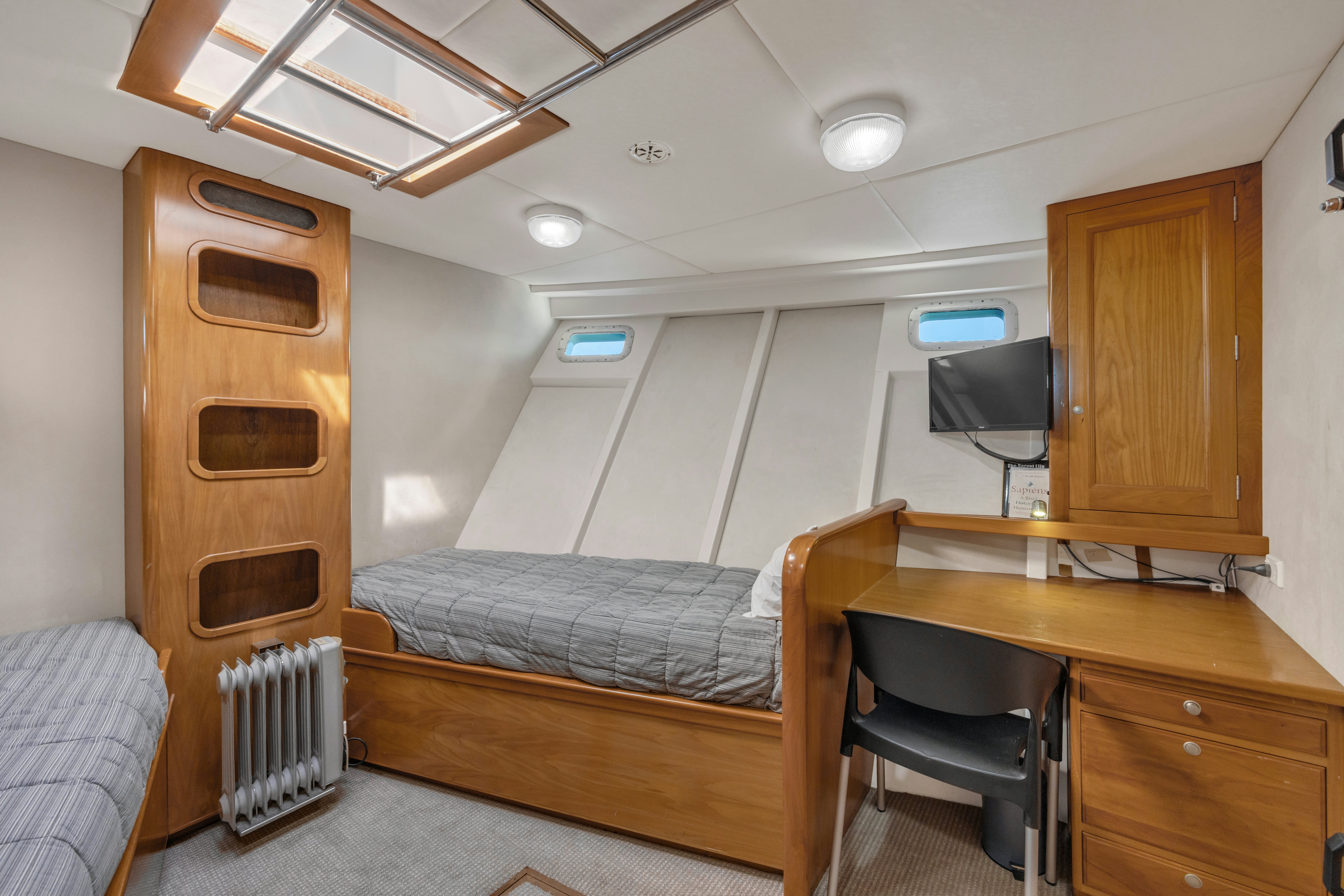 a bedroom with a bed and desk aboard TASMAN Yacht for Sale