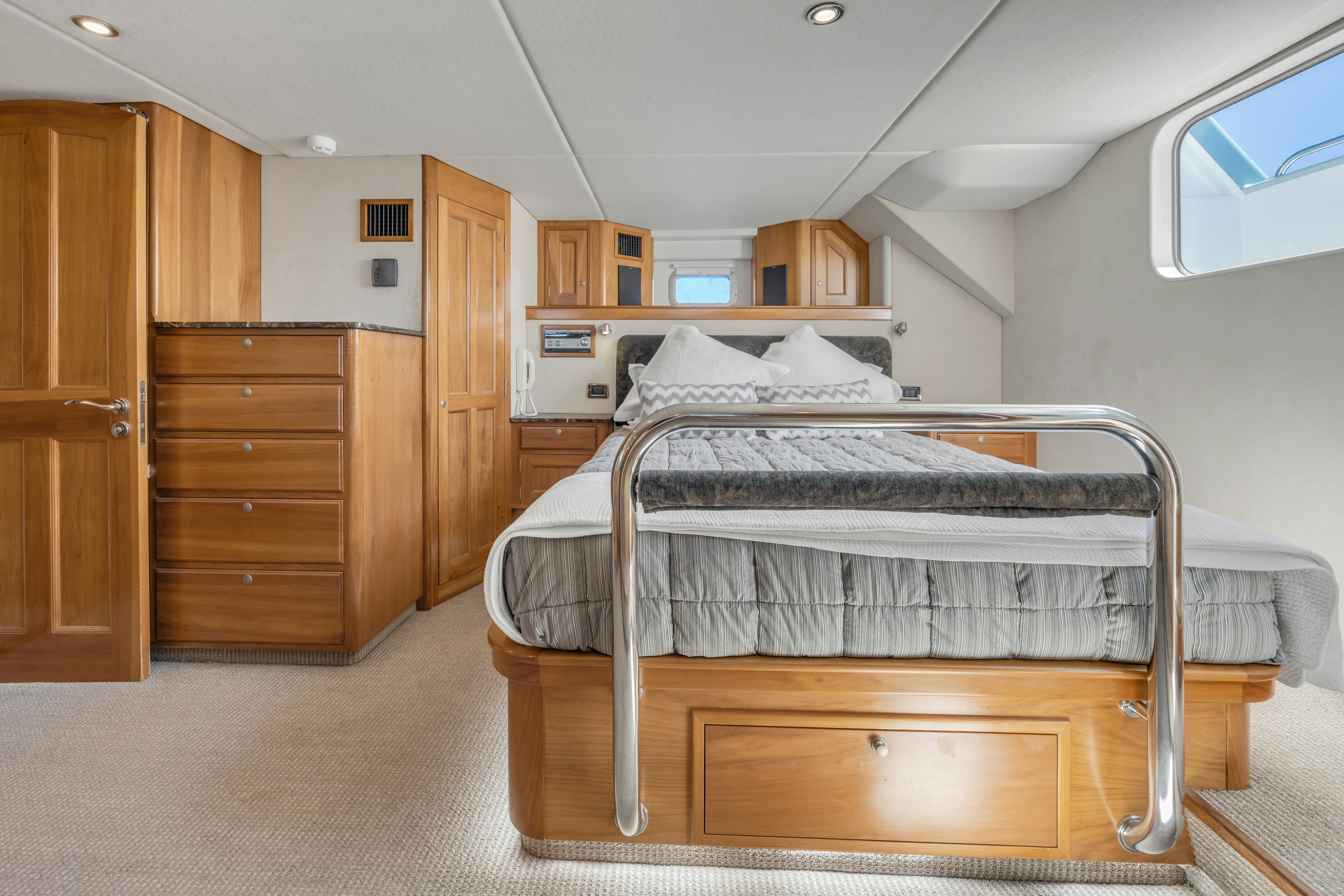 a bedroom with wooden cabinets aboard TASMAN Yacht for Sale