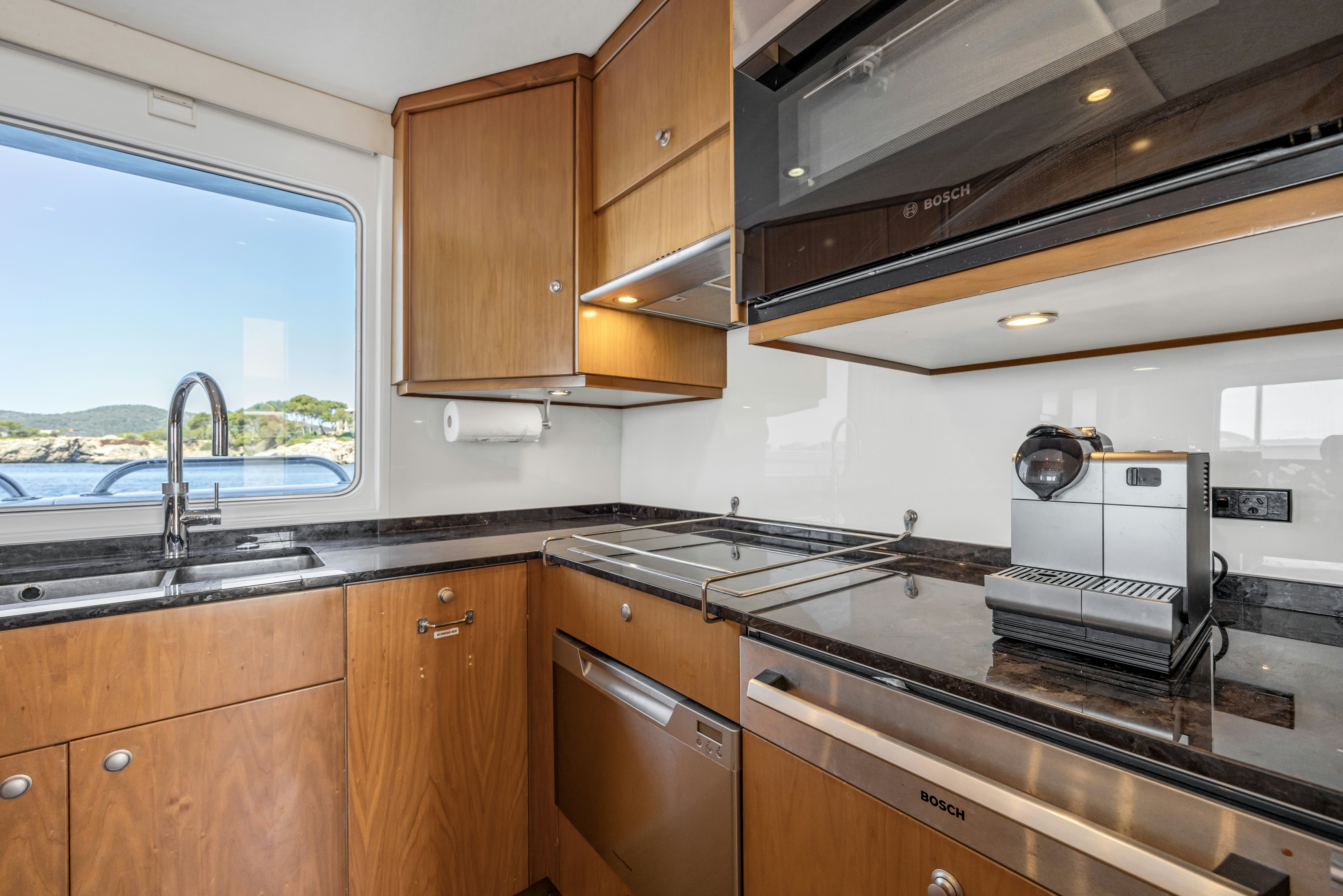 a kitchen with wooden cabinets aboard TASMAN Yacht for Sale