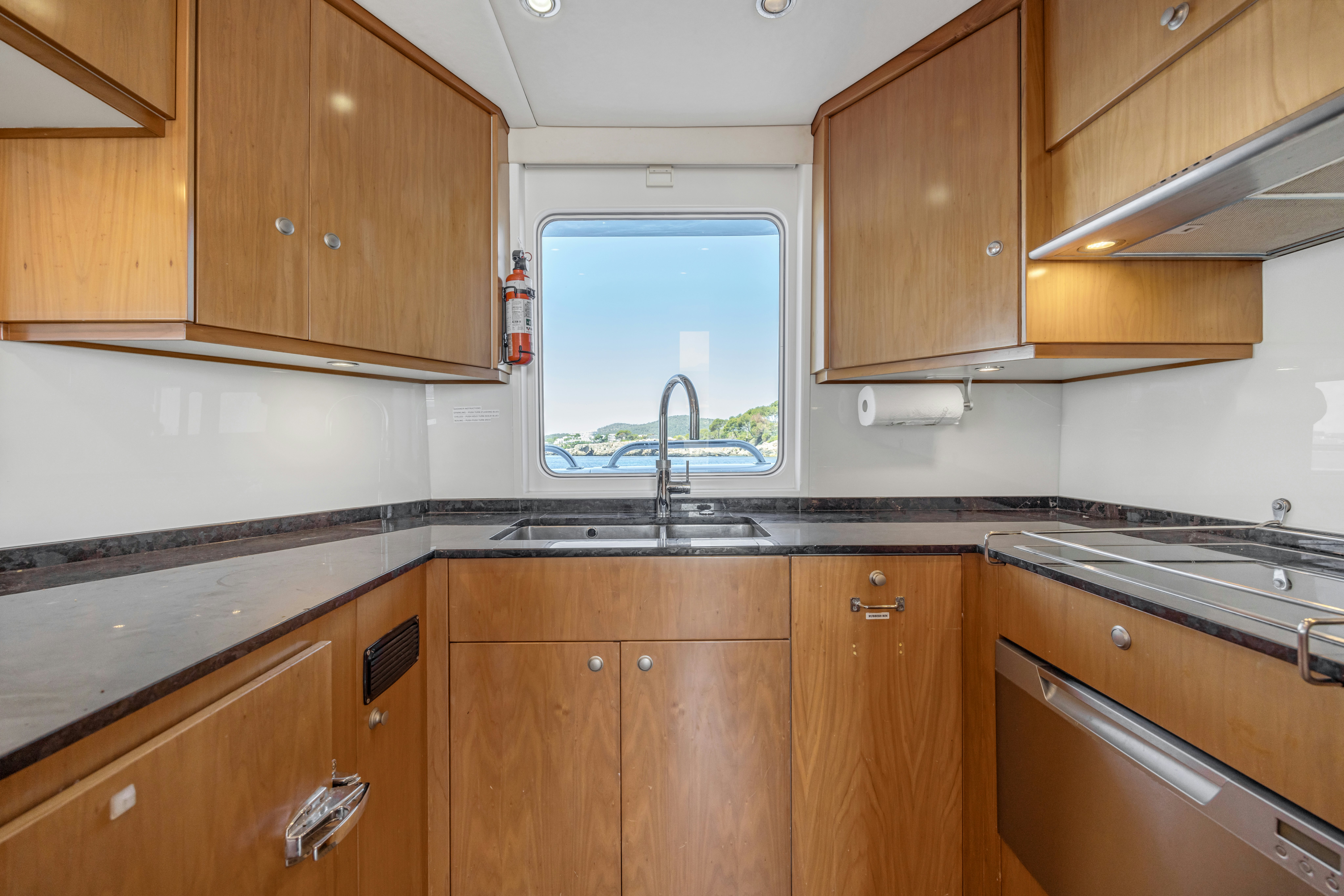 a kitchen with wooden cabinets aboard TASMAN Yacht for Sale