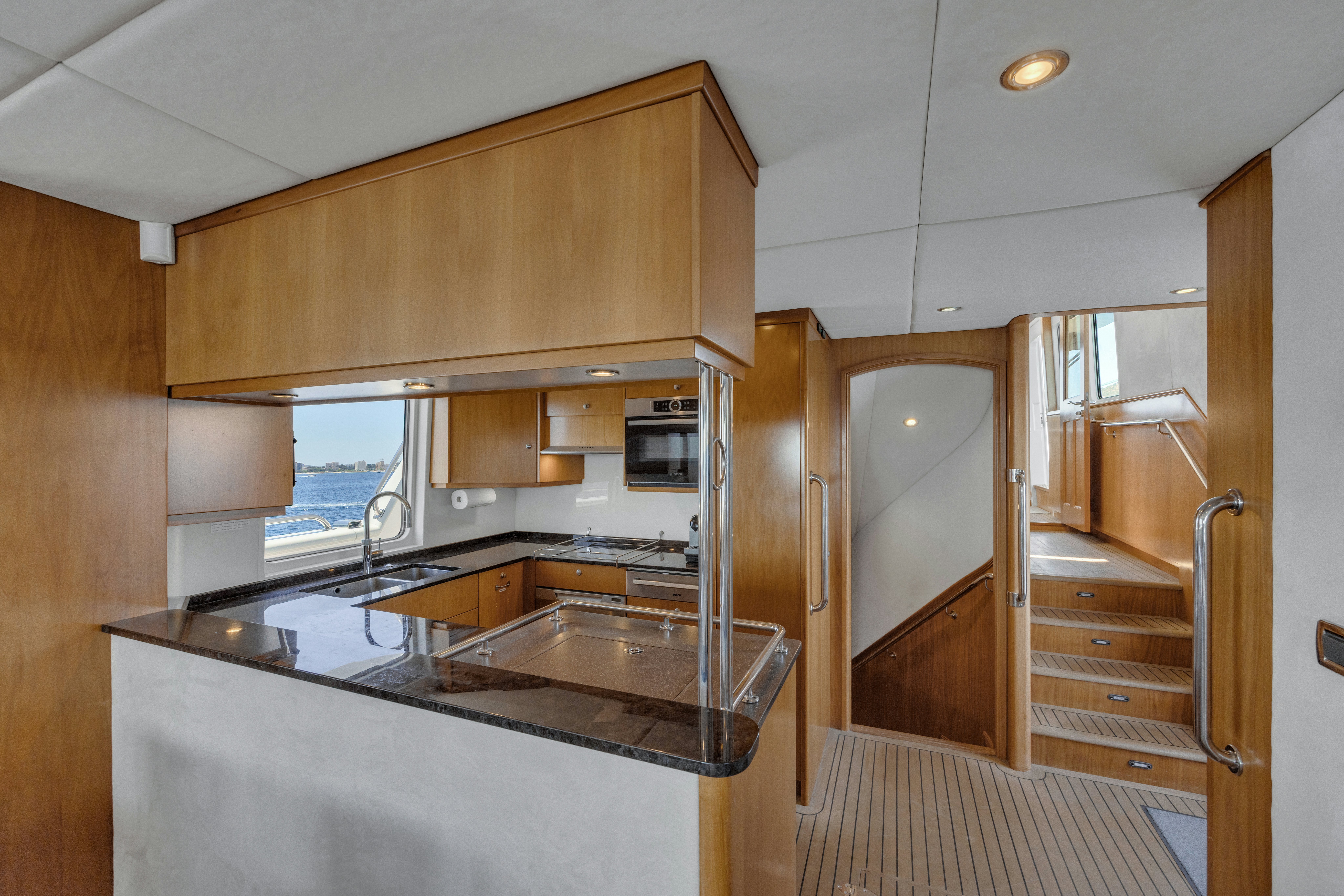 a kitchen with wooden cabinets aboard TASMAN Yacht for Sale
