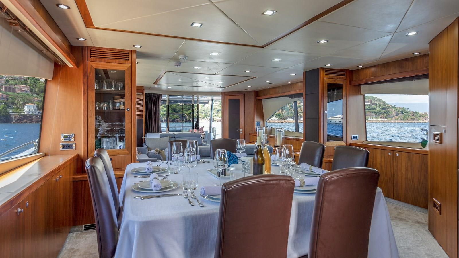 a dining table with a large window aboard MR SEA Yacht for Sale
