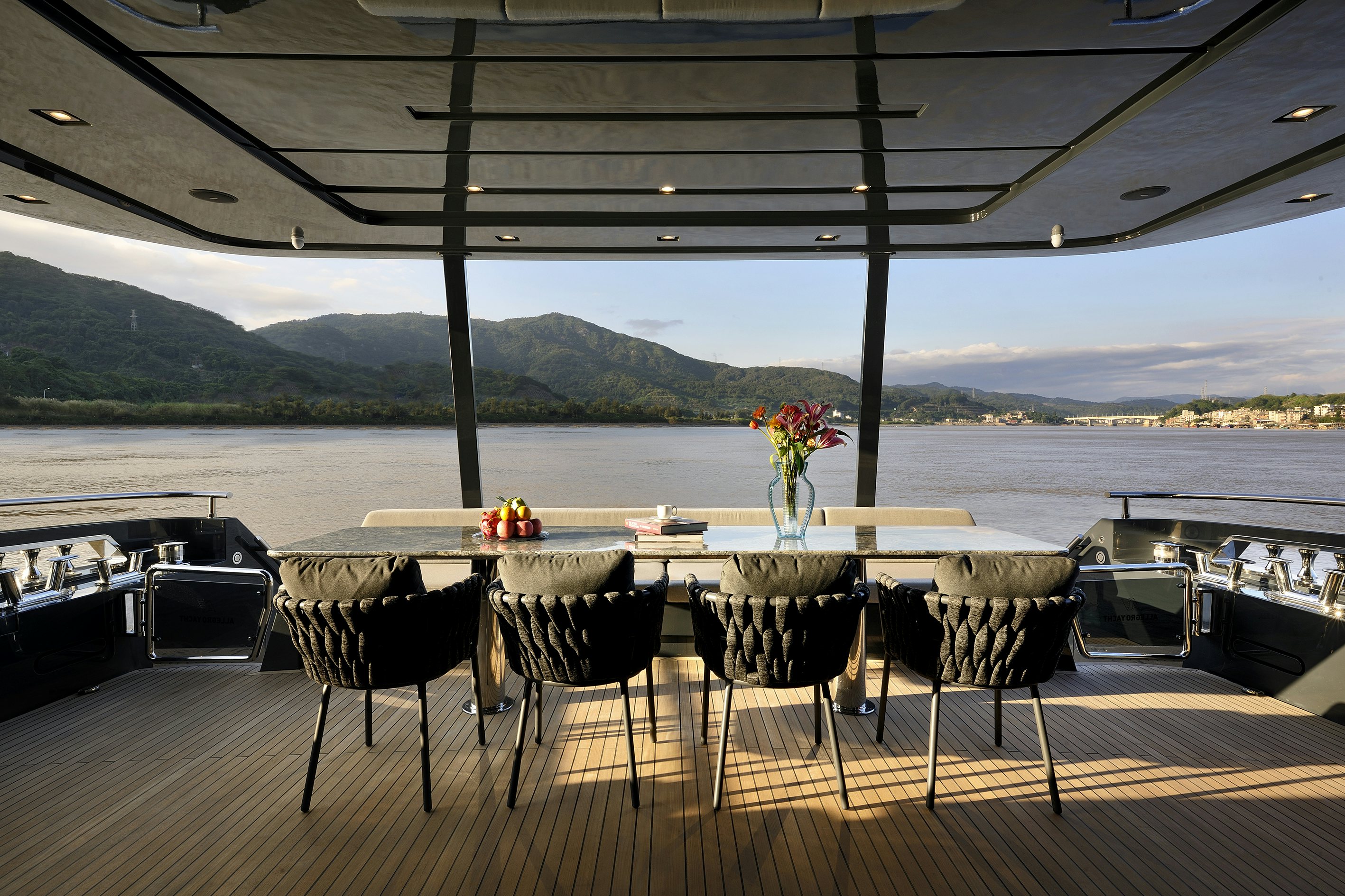 a table set for a meal on a deck overlooking a body of water aboard ALLEGRO FLYBRIDGE 98 Yacht for Sale