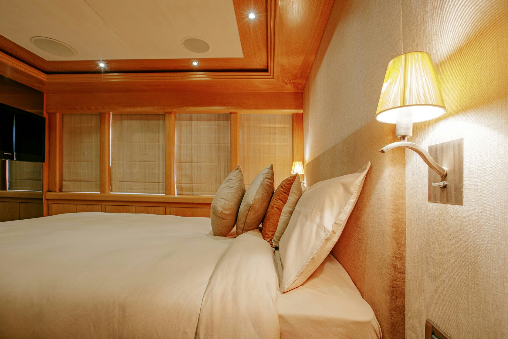 a bed with pillows and a lamp aboard INDIANA Yacht for Charter
