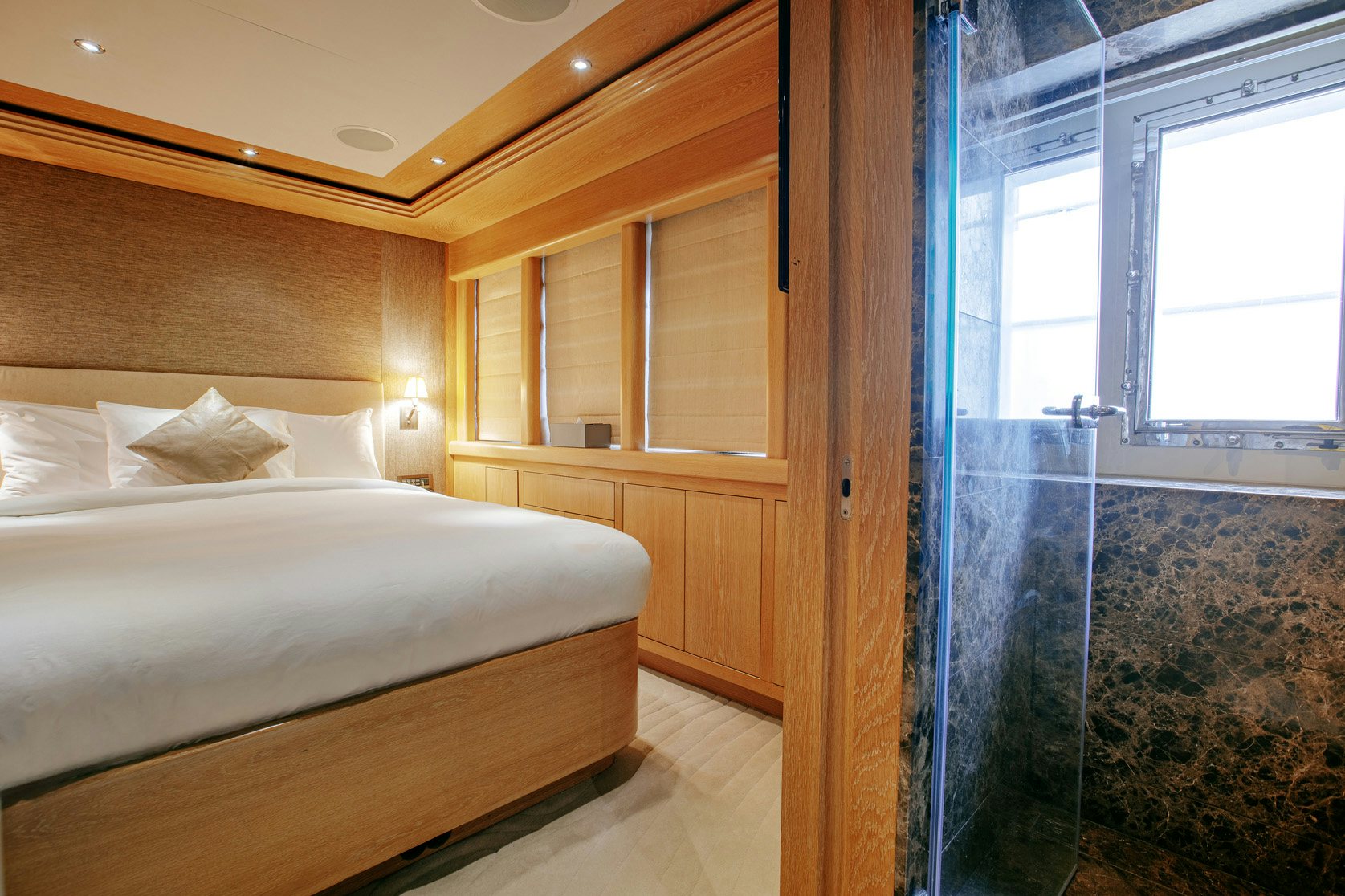 a room with a bed and a window aboard INDIANA Yacht for Charter