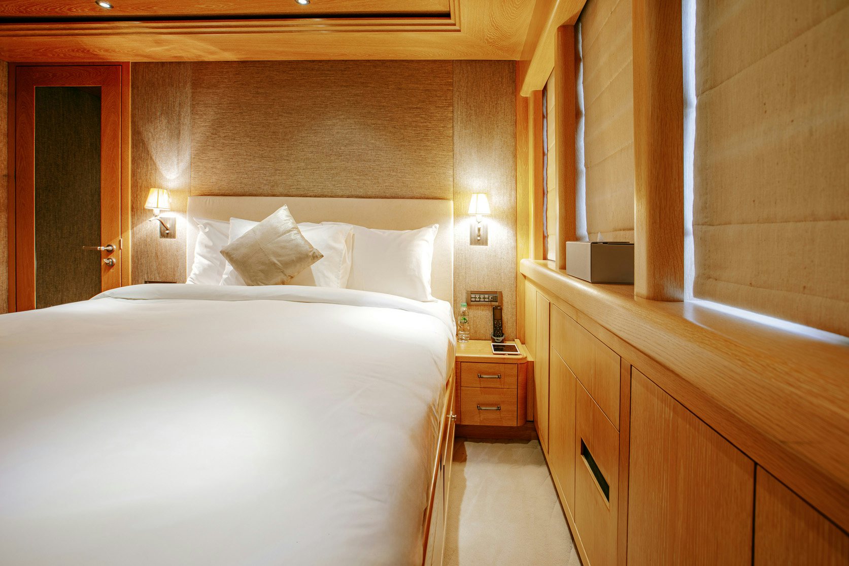 a room with a bed and a dresser aboard INDIANA Yacht for Charter