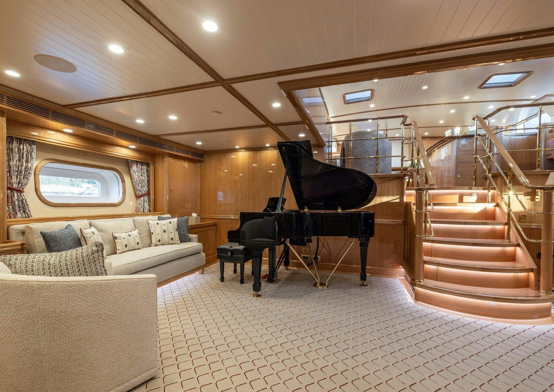 a living room with a staircase and couches aboard MAXIMUS Yacht for Charter