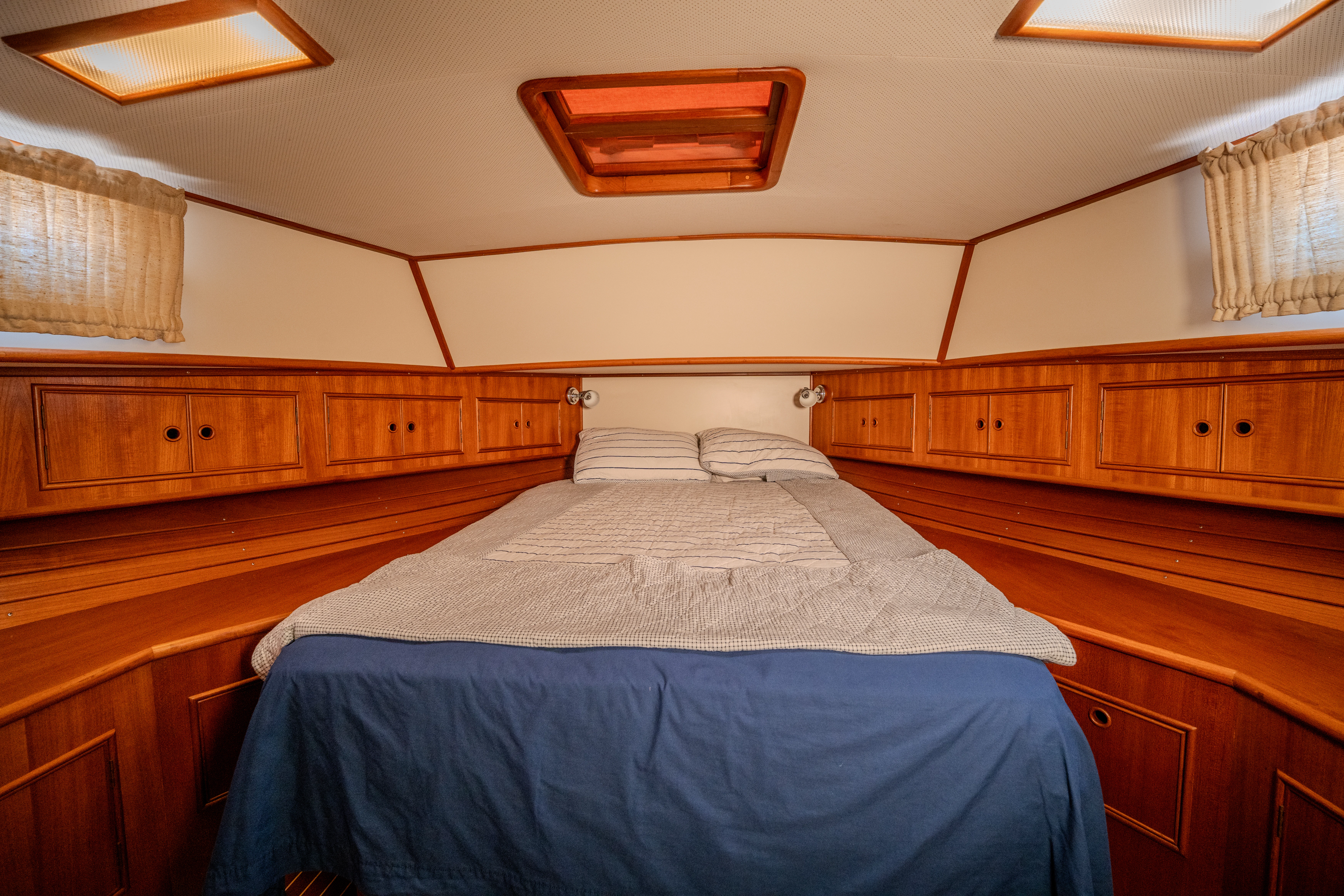 a bedroom with wooden cabinets aboard OSPREY Yacht for Sale