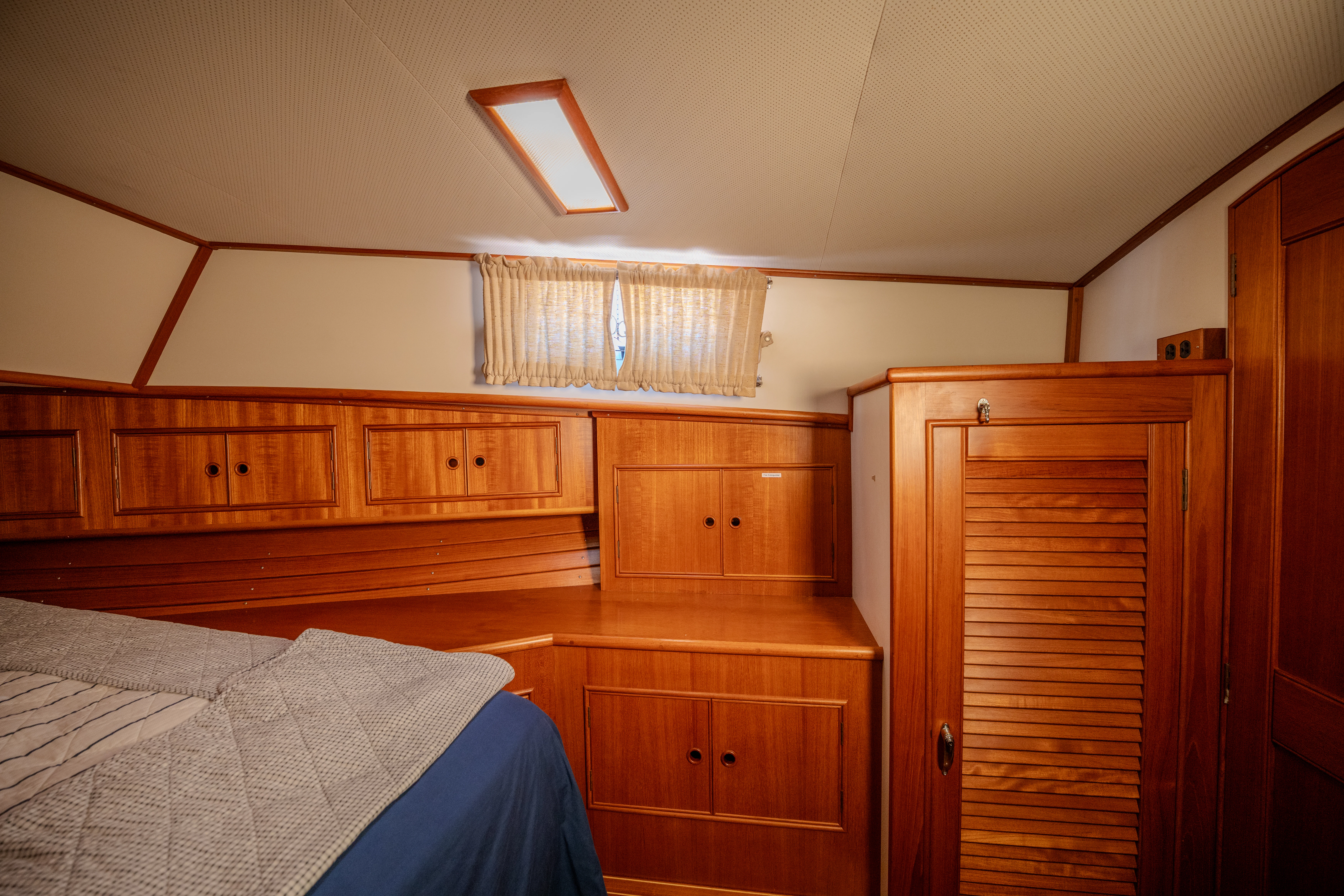 a bedroom with wooden cabinets aboard OSPREY Yacht for Sale