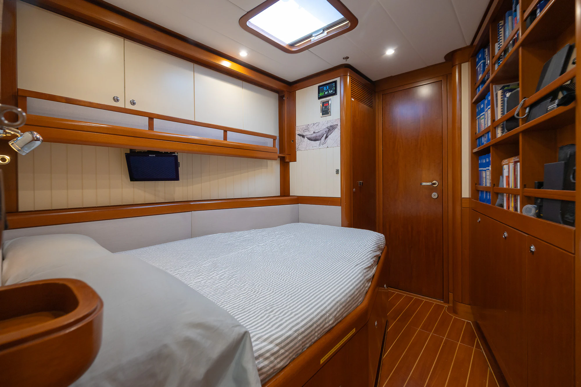 a room with a bed and bookshelves aboard SONG OF THE SEA Yacht for Sale