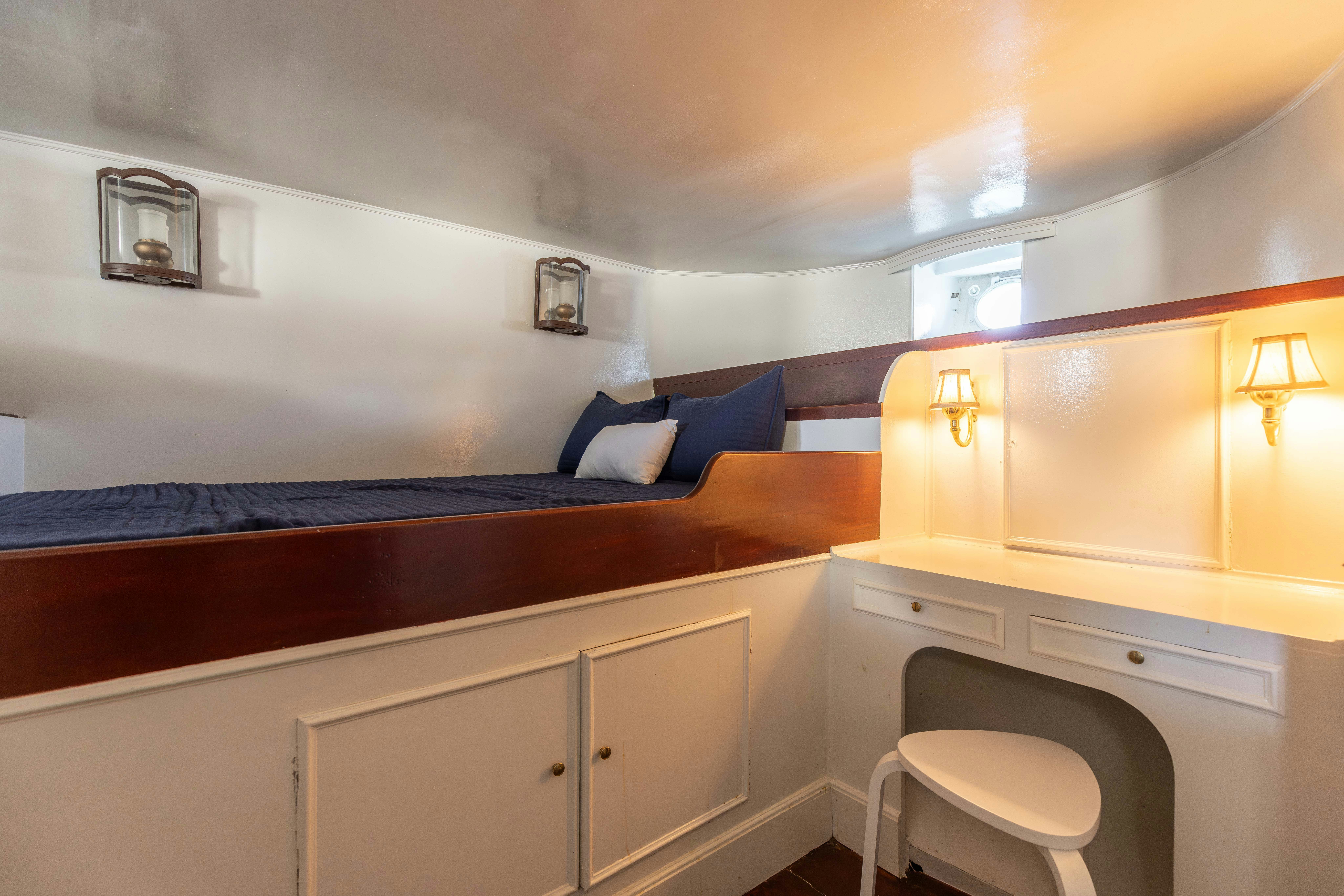 a room with a bed and desk aboard NORTHWIND Yacht for Sale