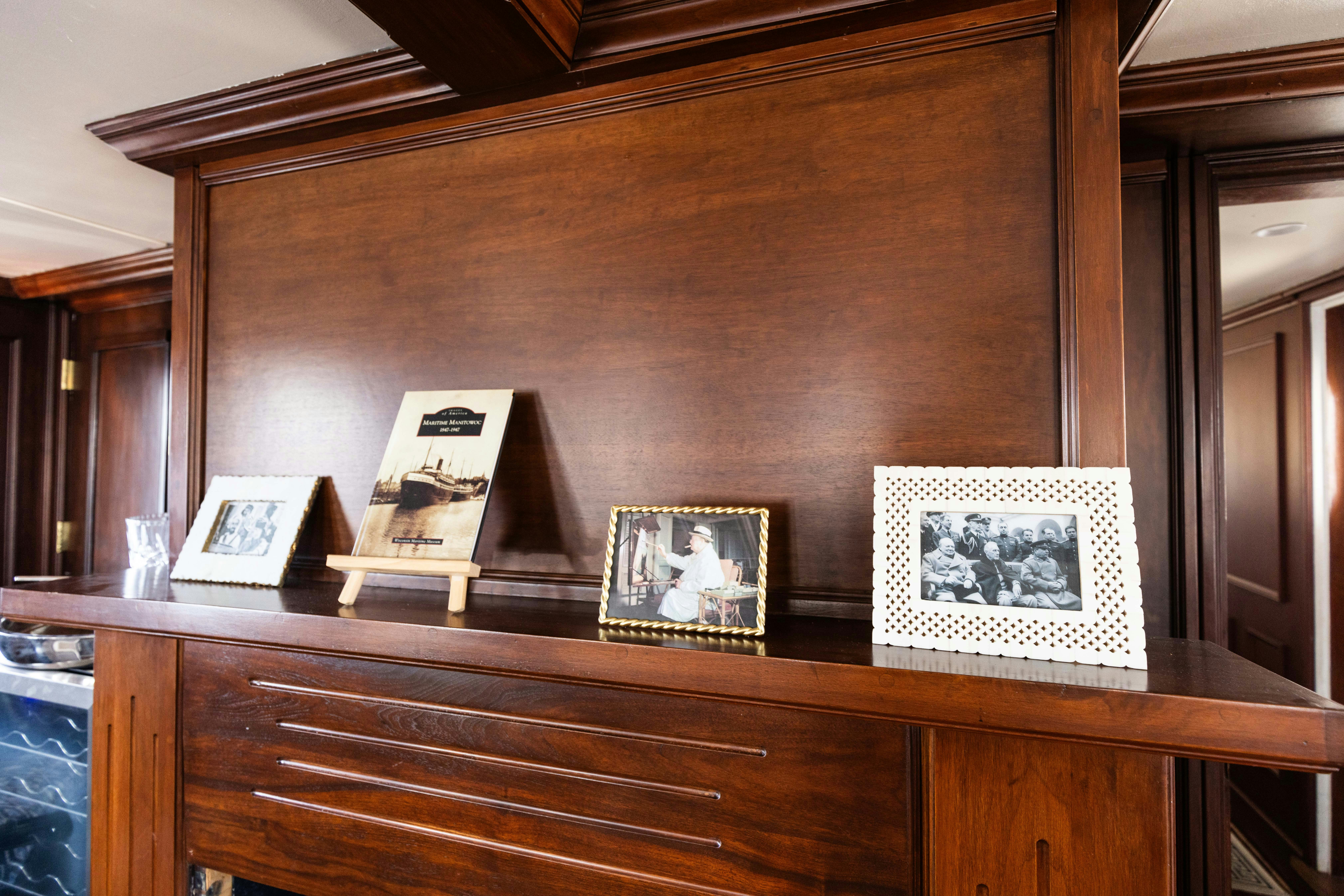a group of framed pictures on a wooden table aboard NORTHWIND Yacht for Sale