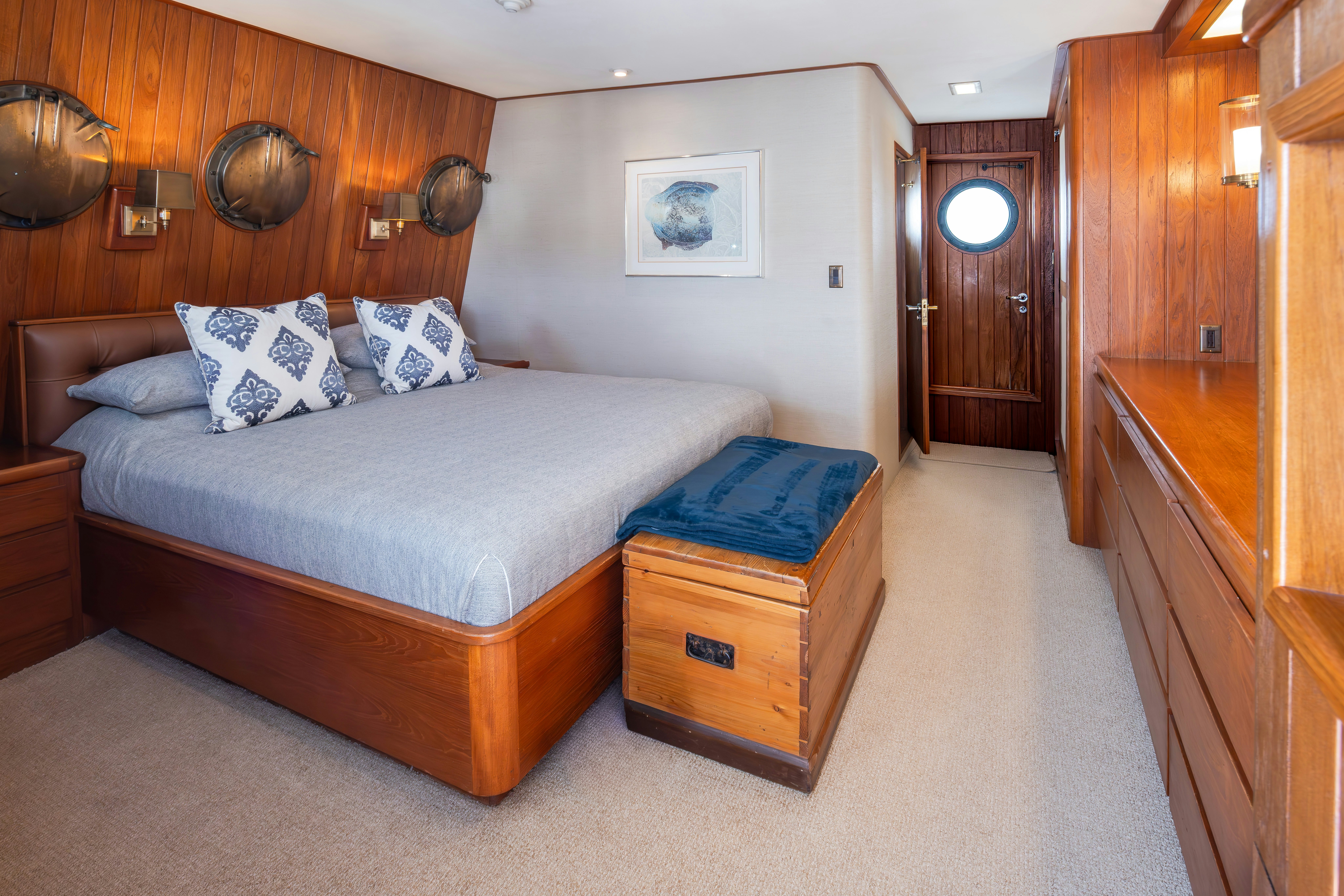 a bedroom with a bed and a dresser aboard SILVERADO Yacht for Sale