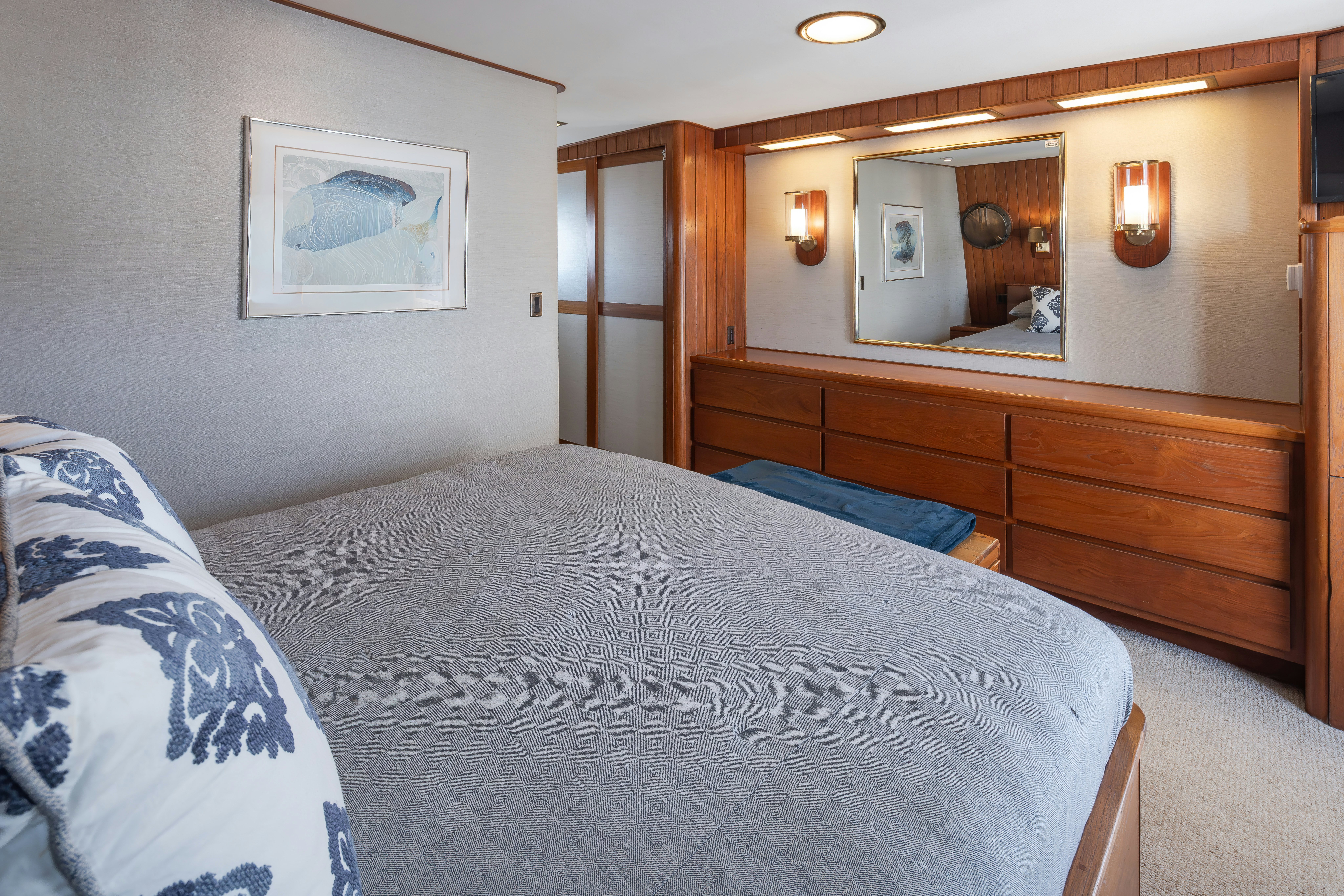 a bedroom with a bed and a mirror aboard SILVERADO Yacht for Sale