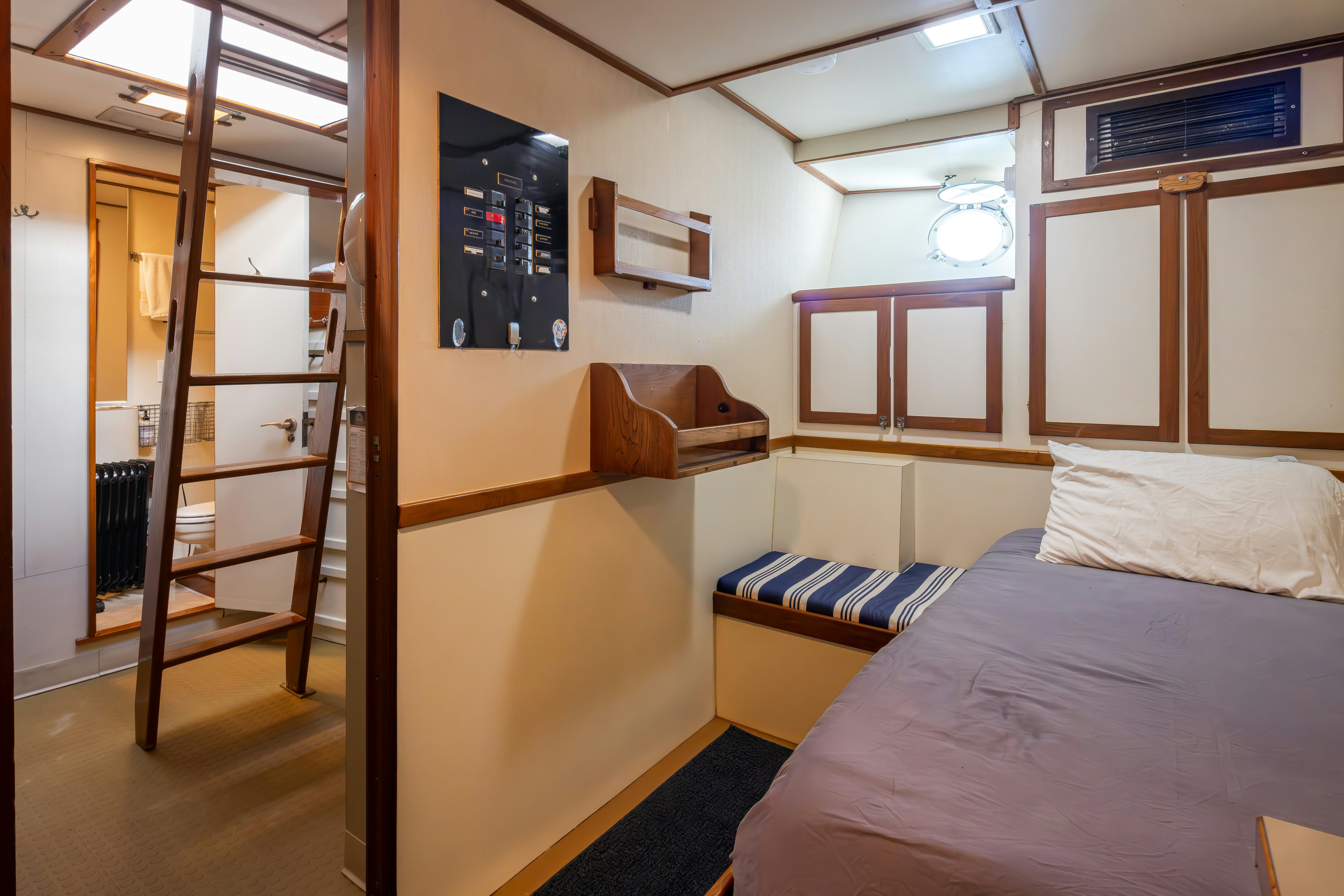 a room with a bed and a bookcase aboard SILVERADO Yacht for Sale
