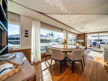 a dining table and chairs on a deck aboard RECORD YEAR Yacht for Charter