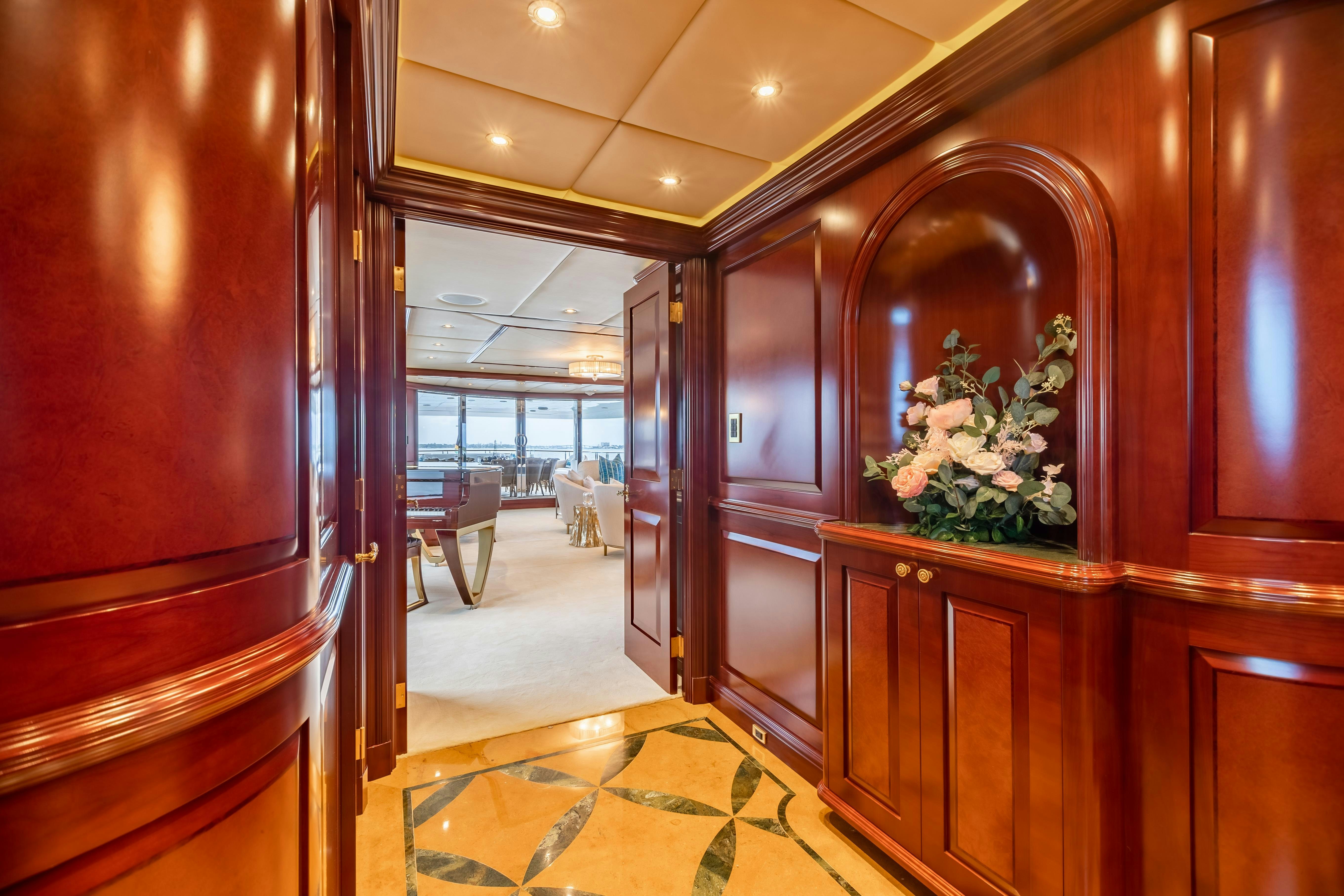 a room with a wood cabinet and a mirror with a flower wreath on it aboard MISS STEPHANIE Yacht for Charter