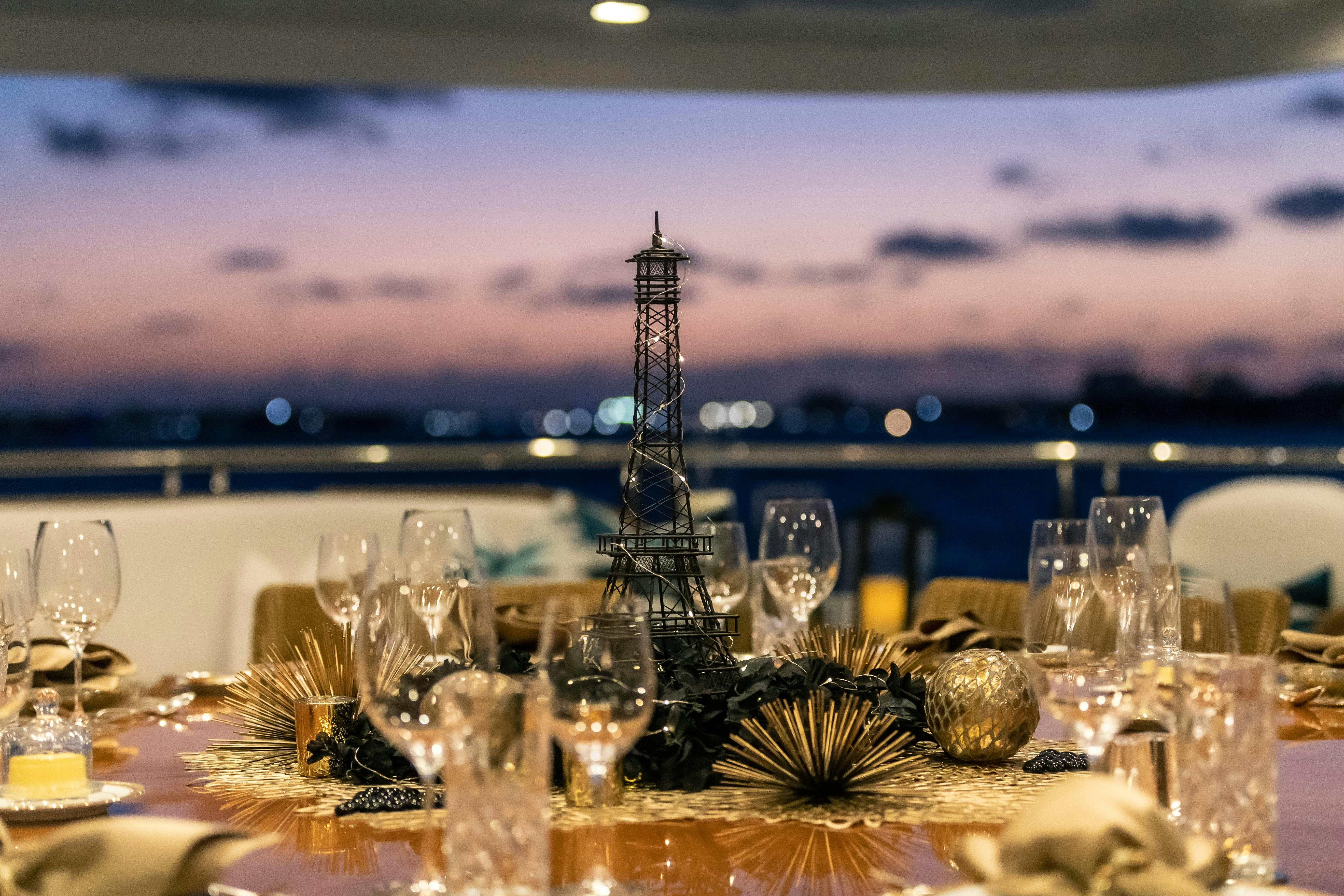 a table with wine glasses and a view of the ocean aboard MISS STEPHANIE Yacht for Charter