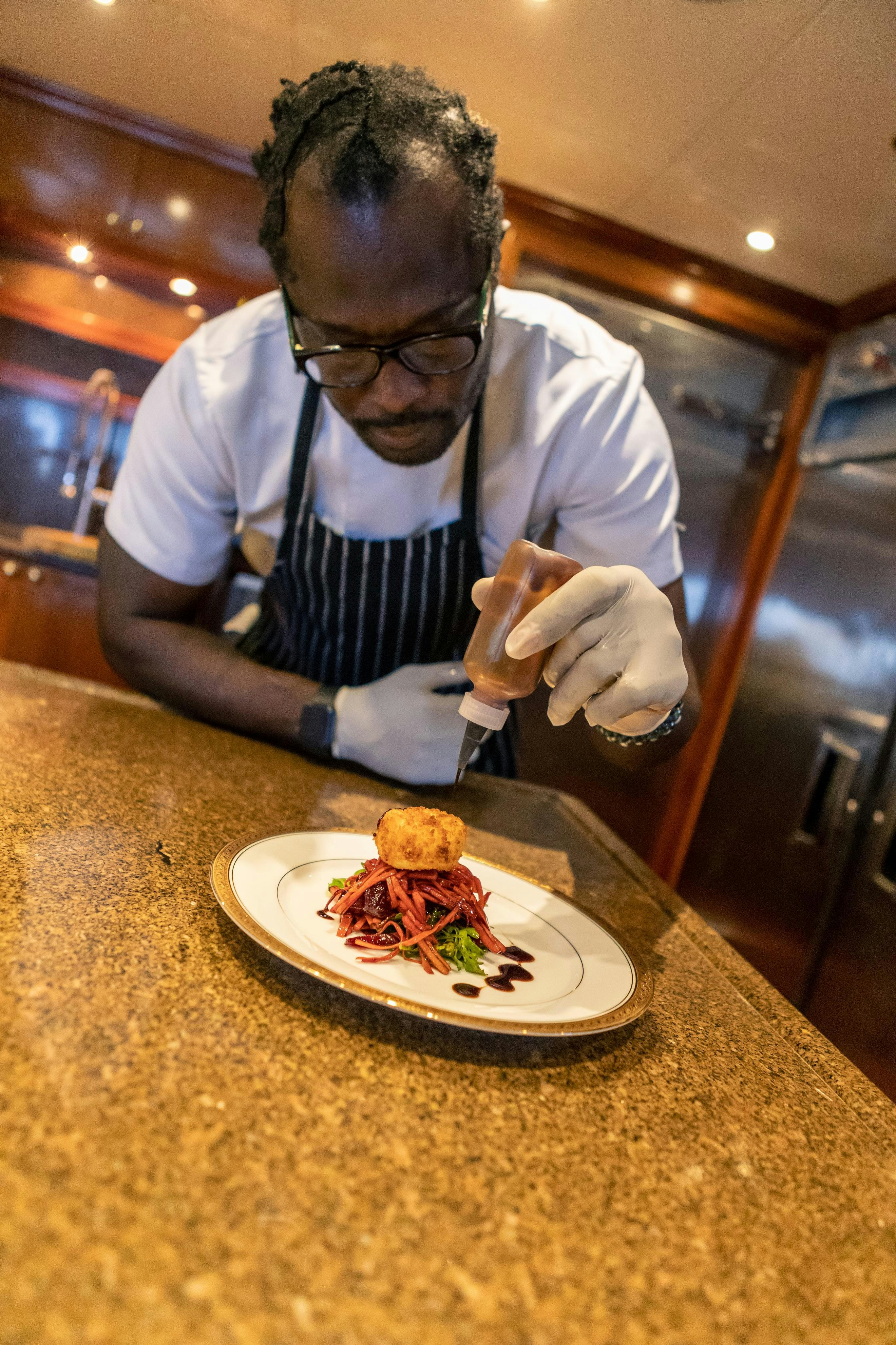 a man cutting a piece of meat aboard MISS STEPHANIE Yacht for Charter