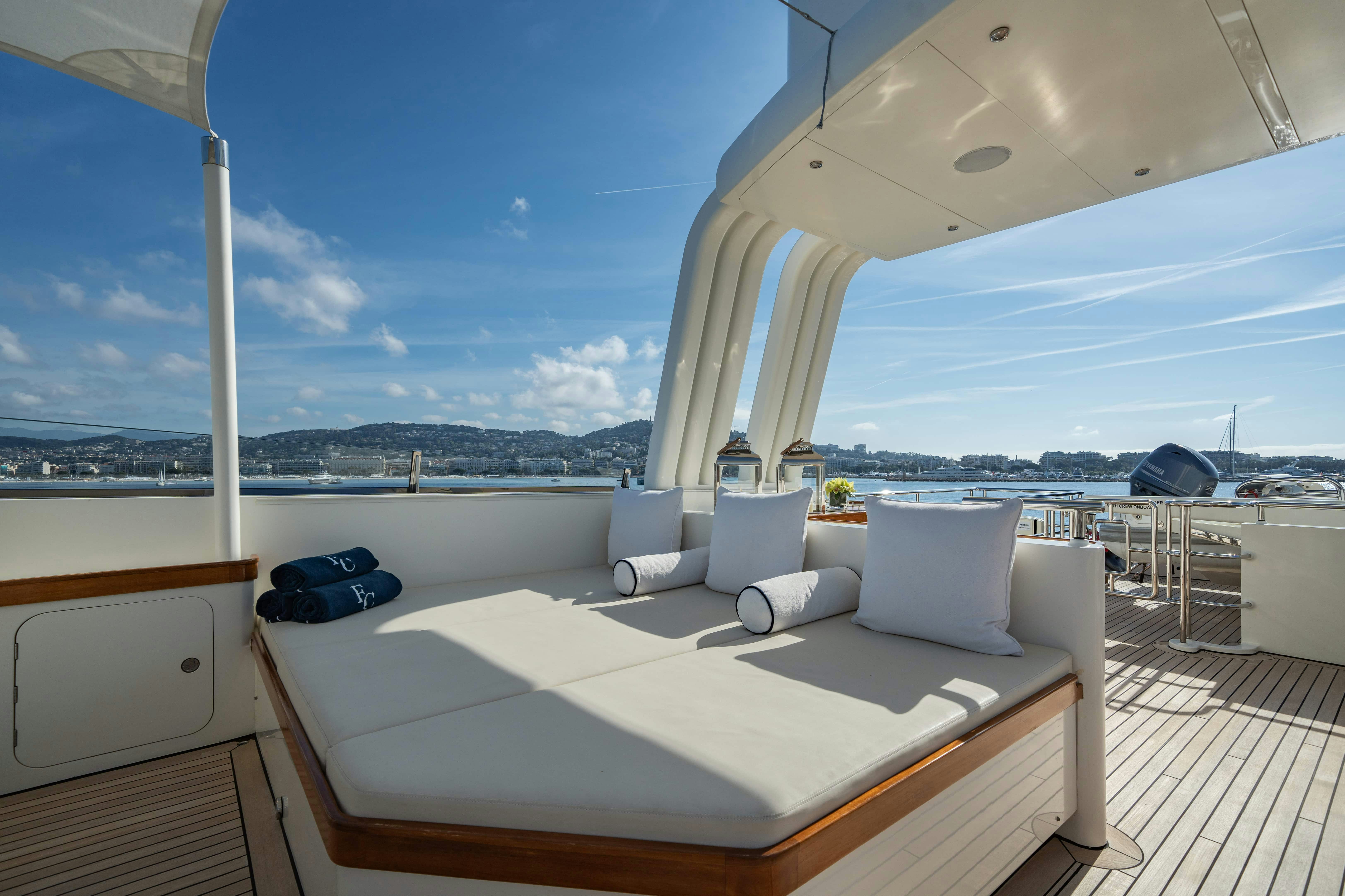 a large white lounge chair on a deck overlooking a body of water aboard FABULOUS CHARACTER Yacht for Charter