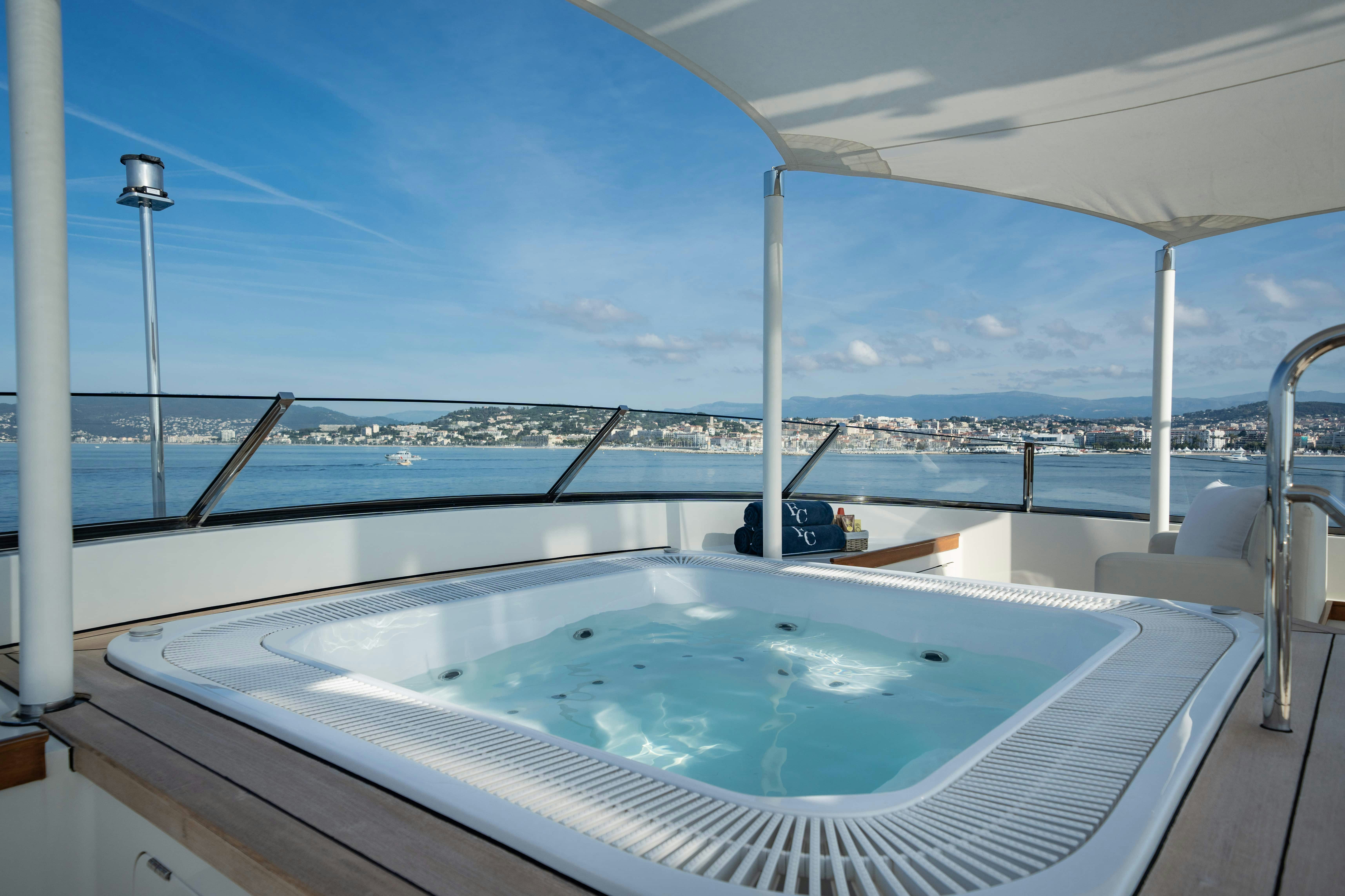 a large pool with a view of a city and water aboard FABULOUS CHARACTER Yacht for Charter