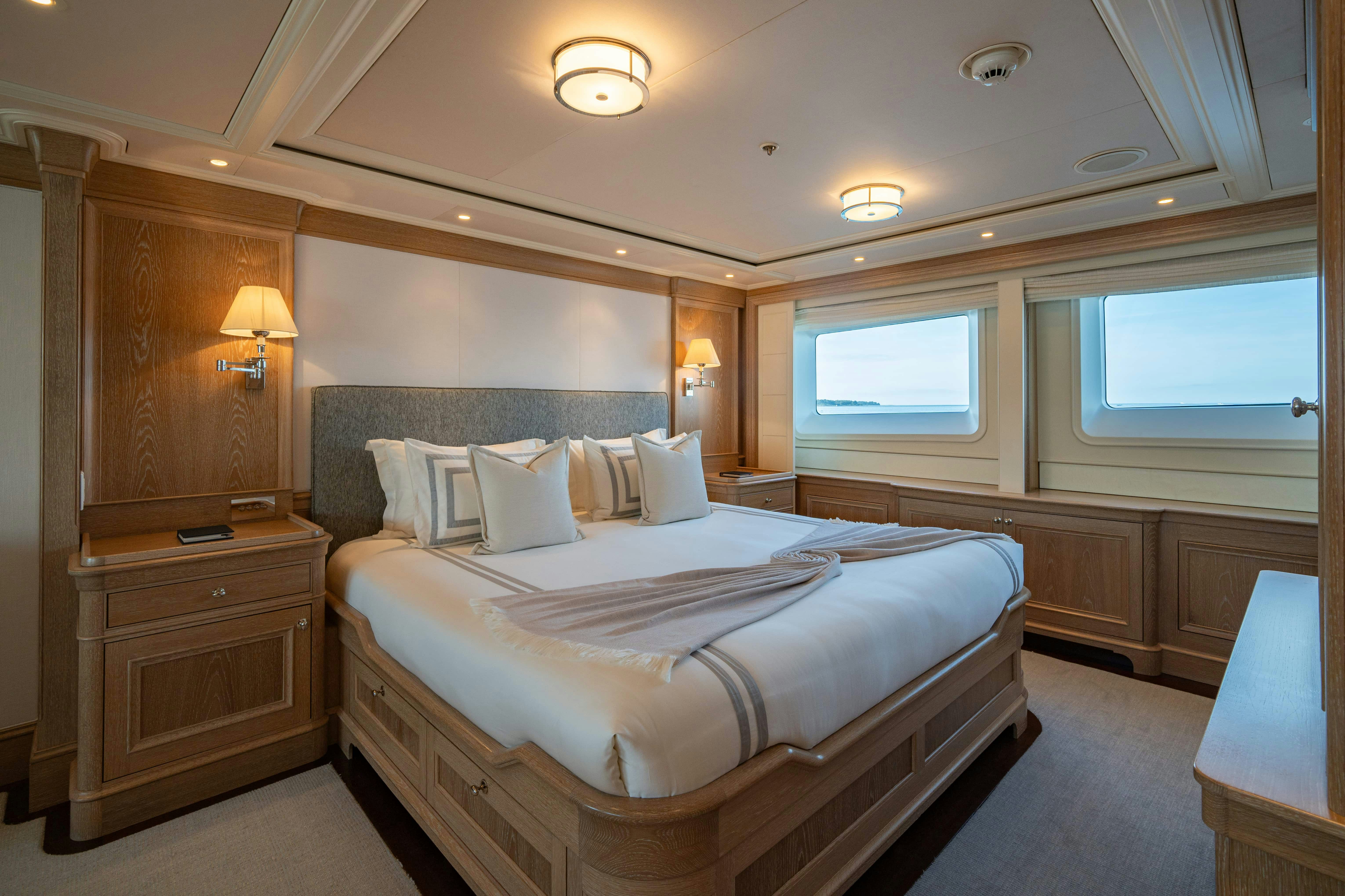 a bedroom with a bed and a dresser aboard FABULOUS CHARACTER Yacht for Charter
