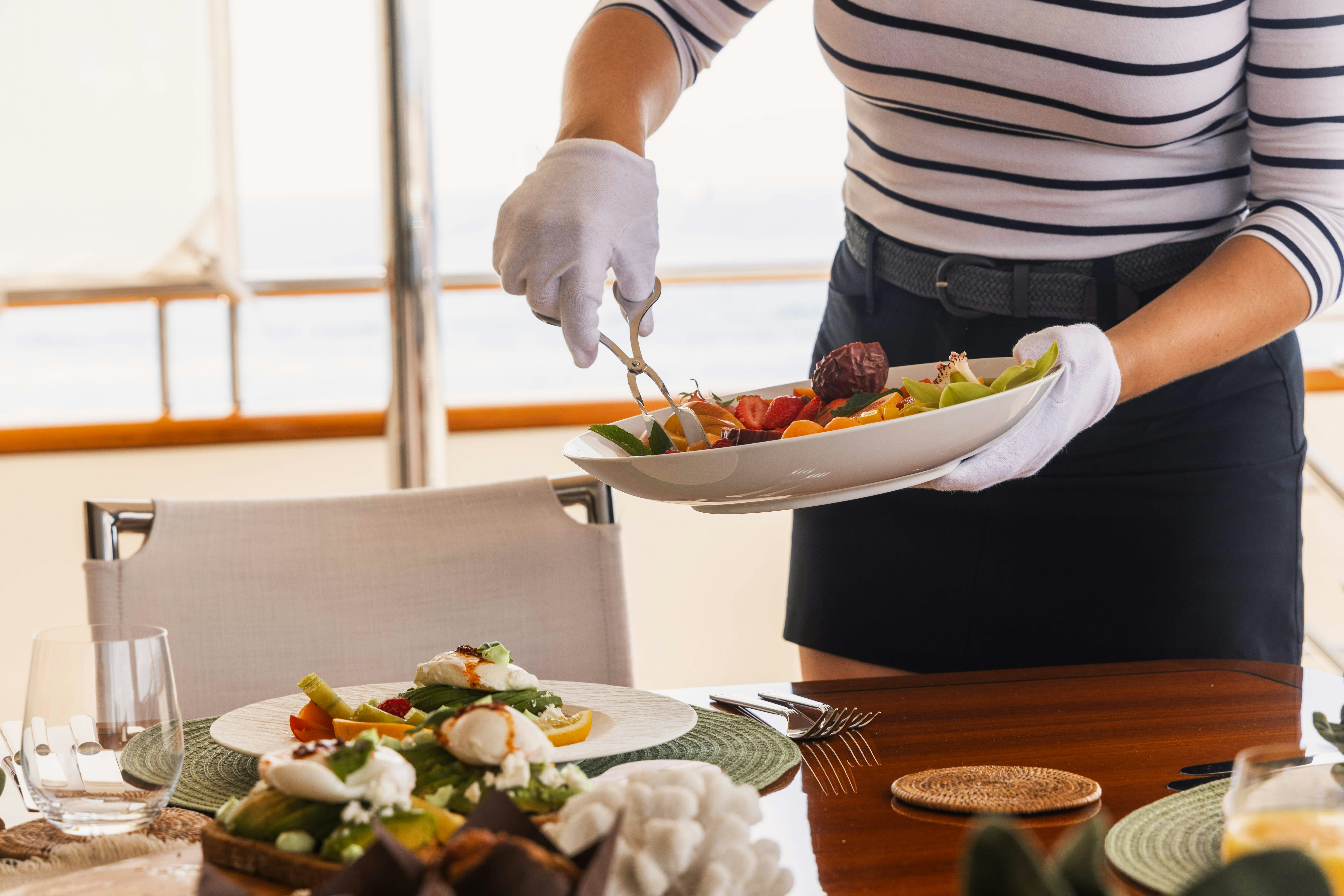 a person preparing food on a plate aboard FABULOUS CHARACTER Yacht for Charter