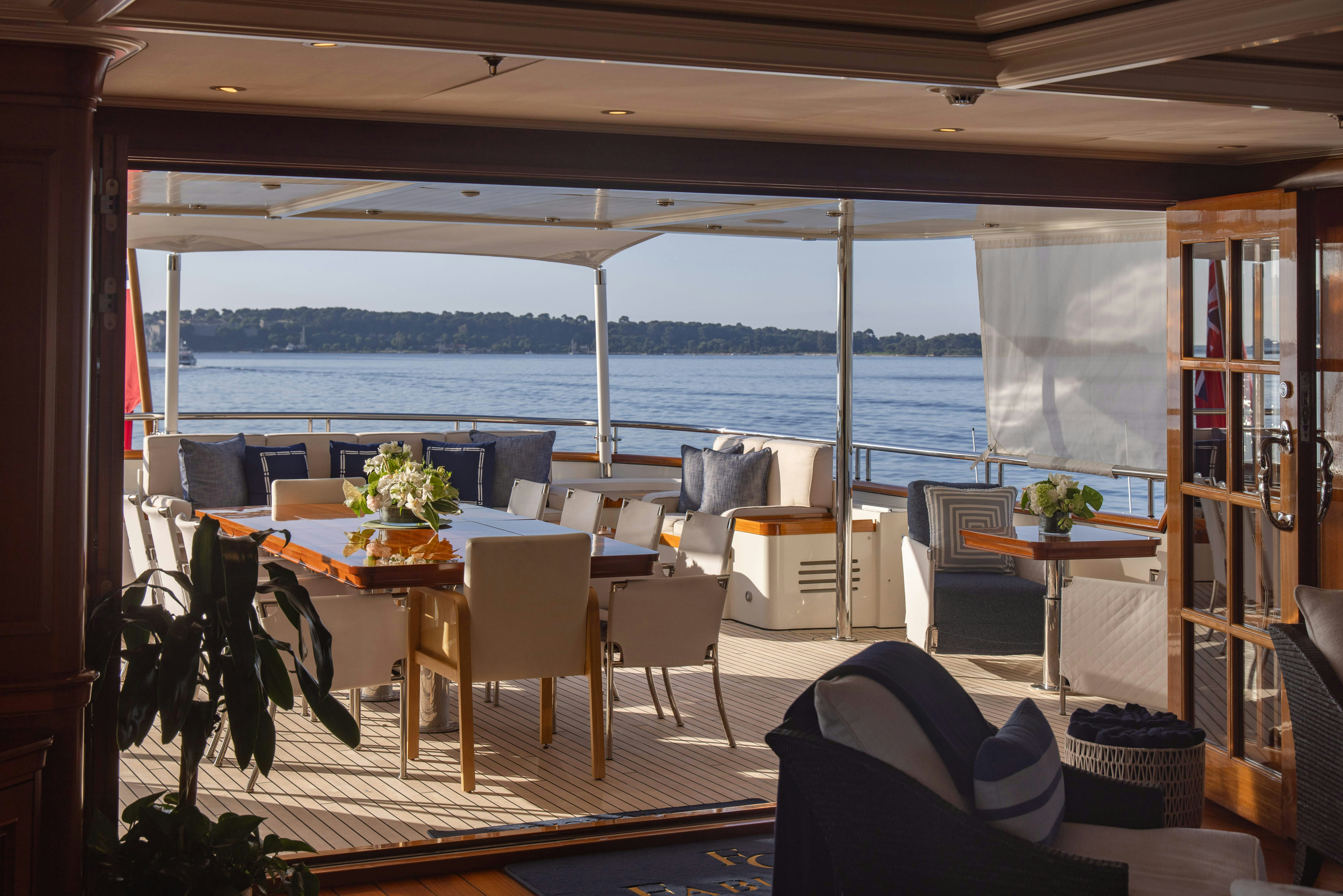 a room with a table chairs and plants on the table aboard FABULOUS CHARACTER Yacht for Charter