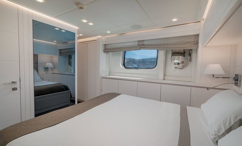 a room with a bed and a mirror aboard SANDS Yacht for Charter