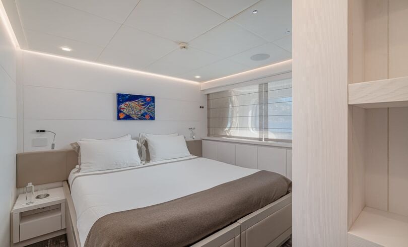 a bed with white sheets aboard SANDS Yacht for Charter