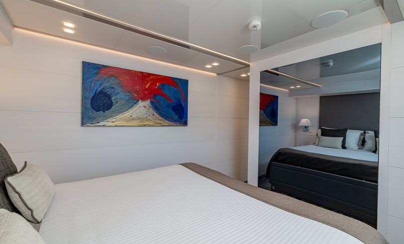 a bedroom with a bed and a painting on the wall aboard SANDS Yacht for Charter