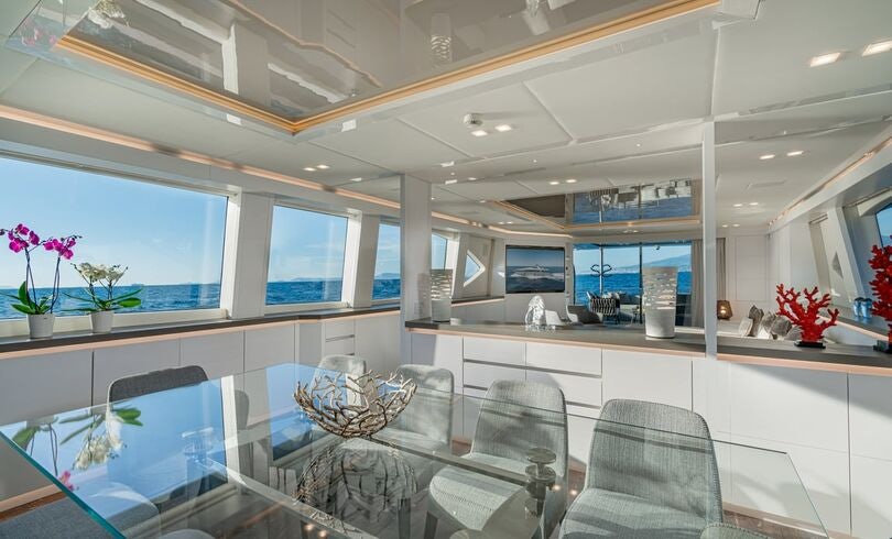 a large room with a table and chairs aboard SANDS Yacht for Charter