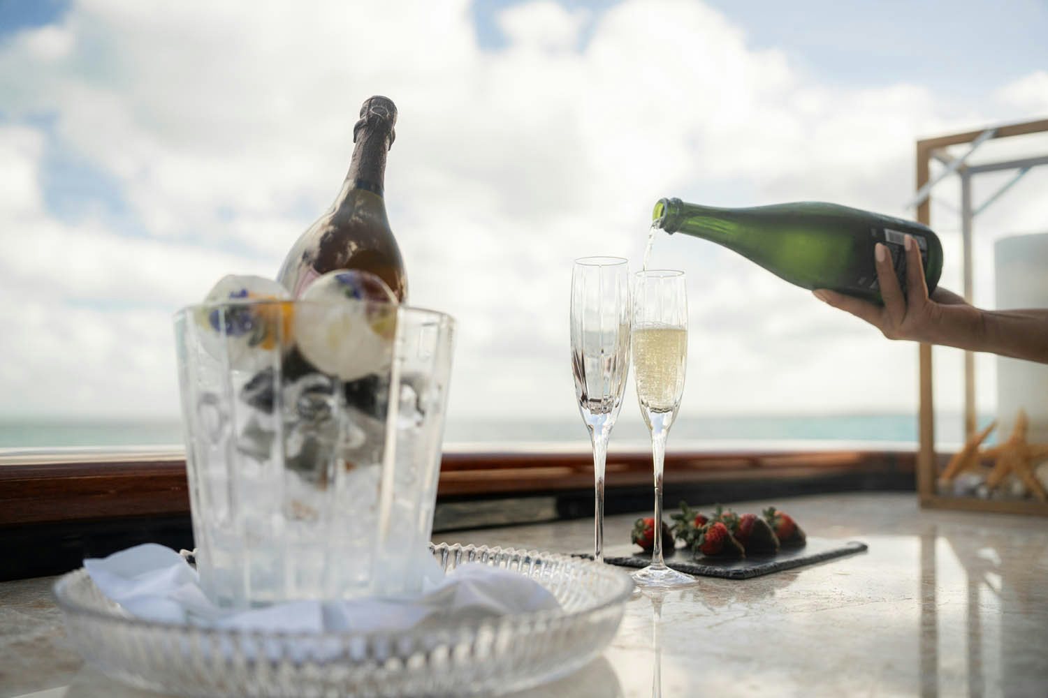 a person pouring wine into a glass aboard NICOLE EVELYN Yacht for Charter