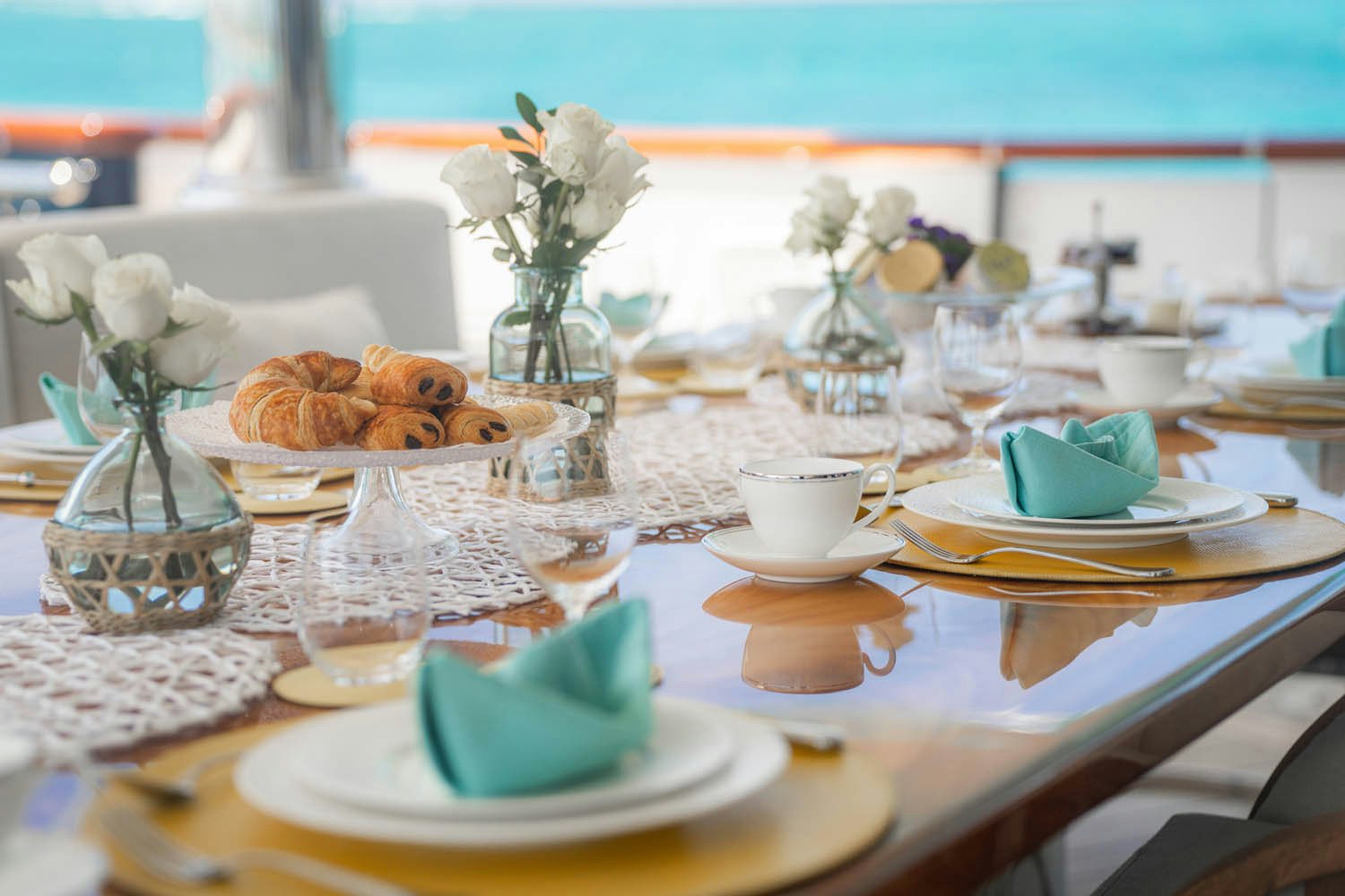 a table with plates and glasses aboard NICOLE EVELYN Yacht for Charter