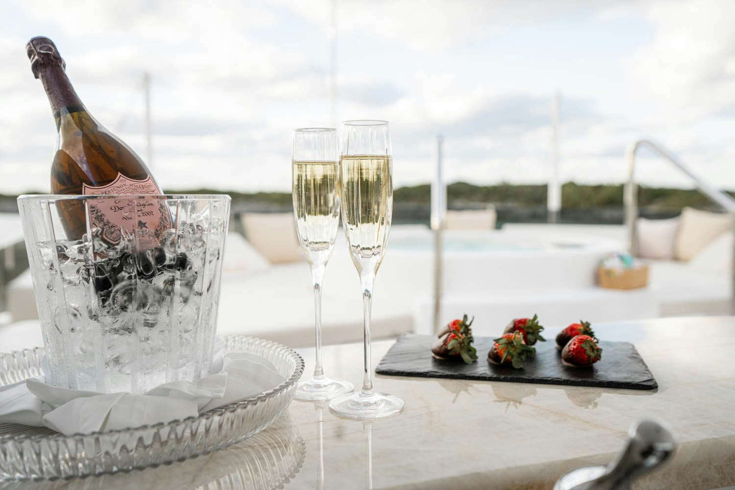 a table with glasses and a bottle of champagne on it aboard NICOLE EVELYN Yacht for Charter