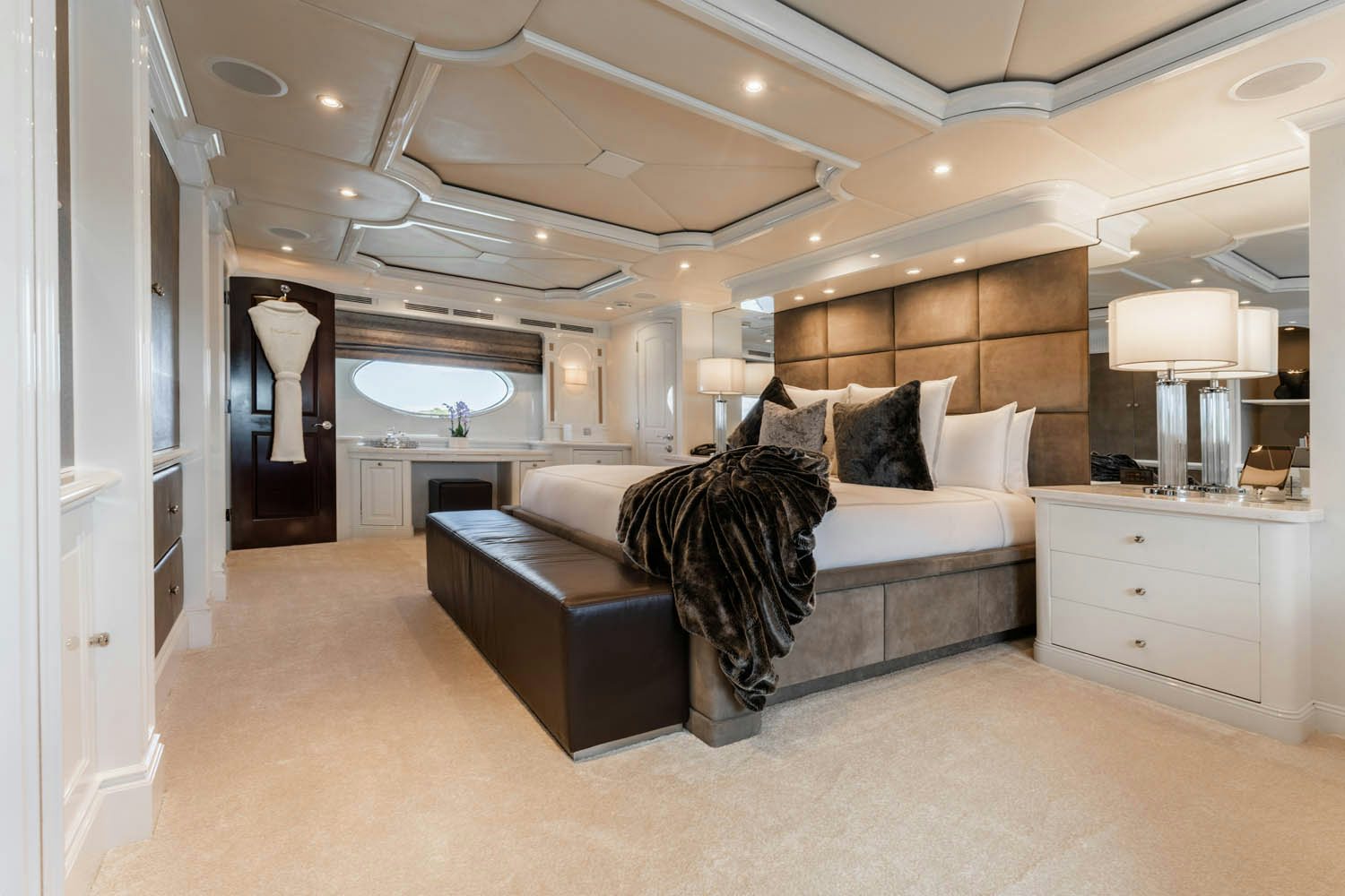 a large living room with a black couch and a large mirror aboard NICOLE EVELYN Yacht for Charter