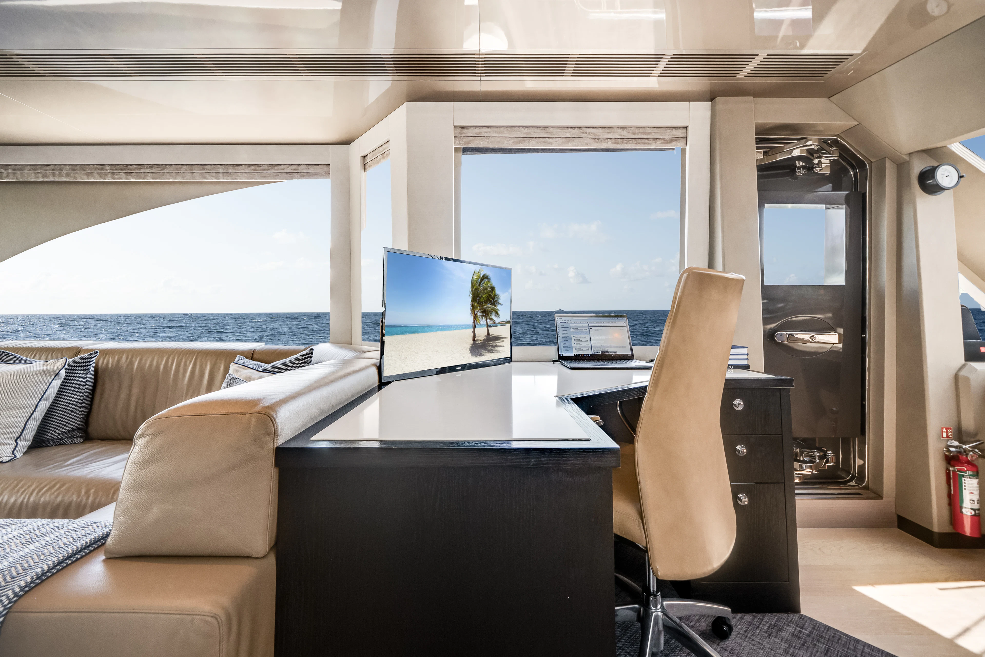 a room with a large window and a table with chairs and a view of the ocean aboard JUST A VACATION Yacht for Sale