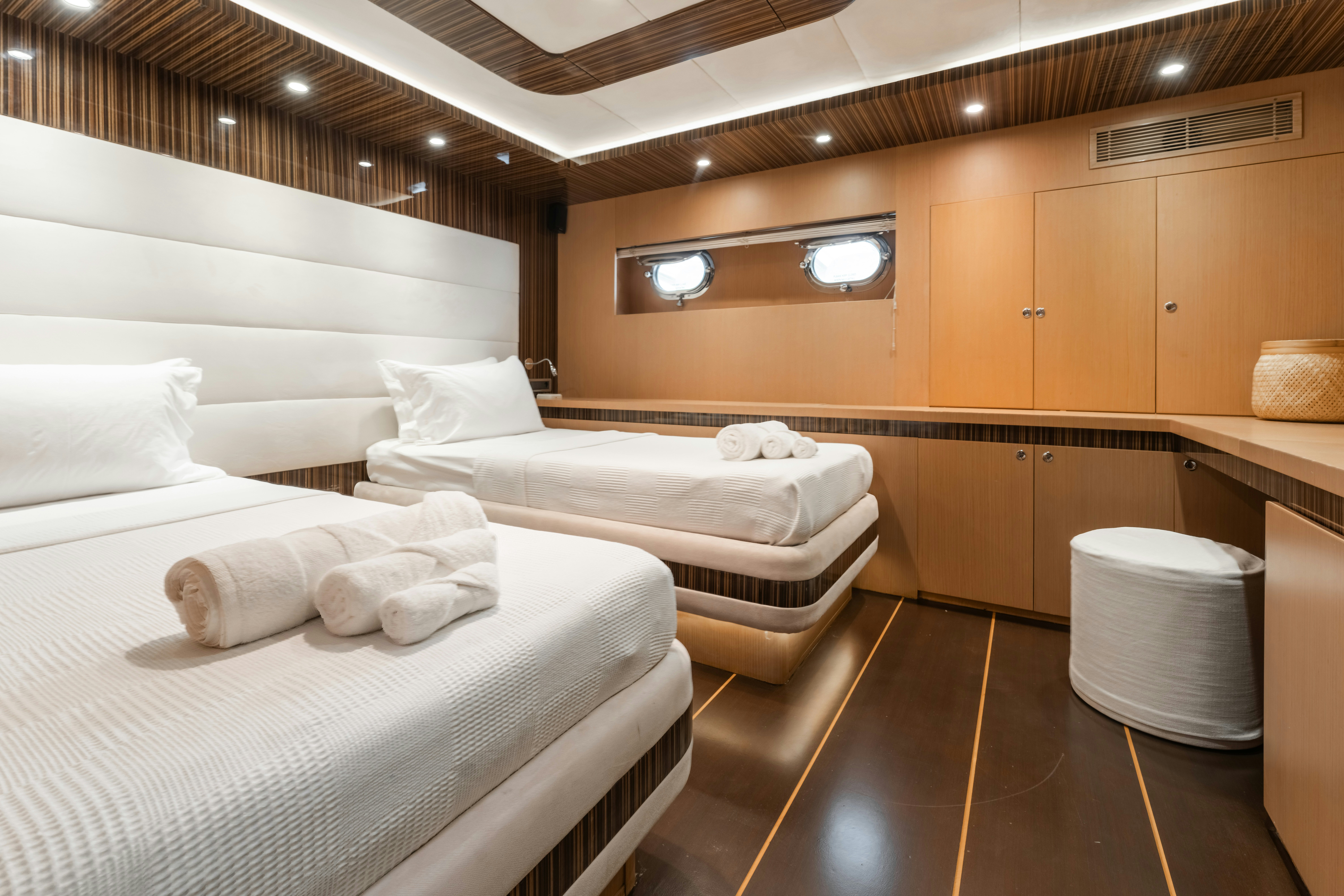 a room with beds and a wood floor aboard LE PIETRE Yacht for Sale