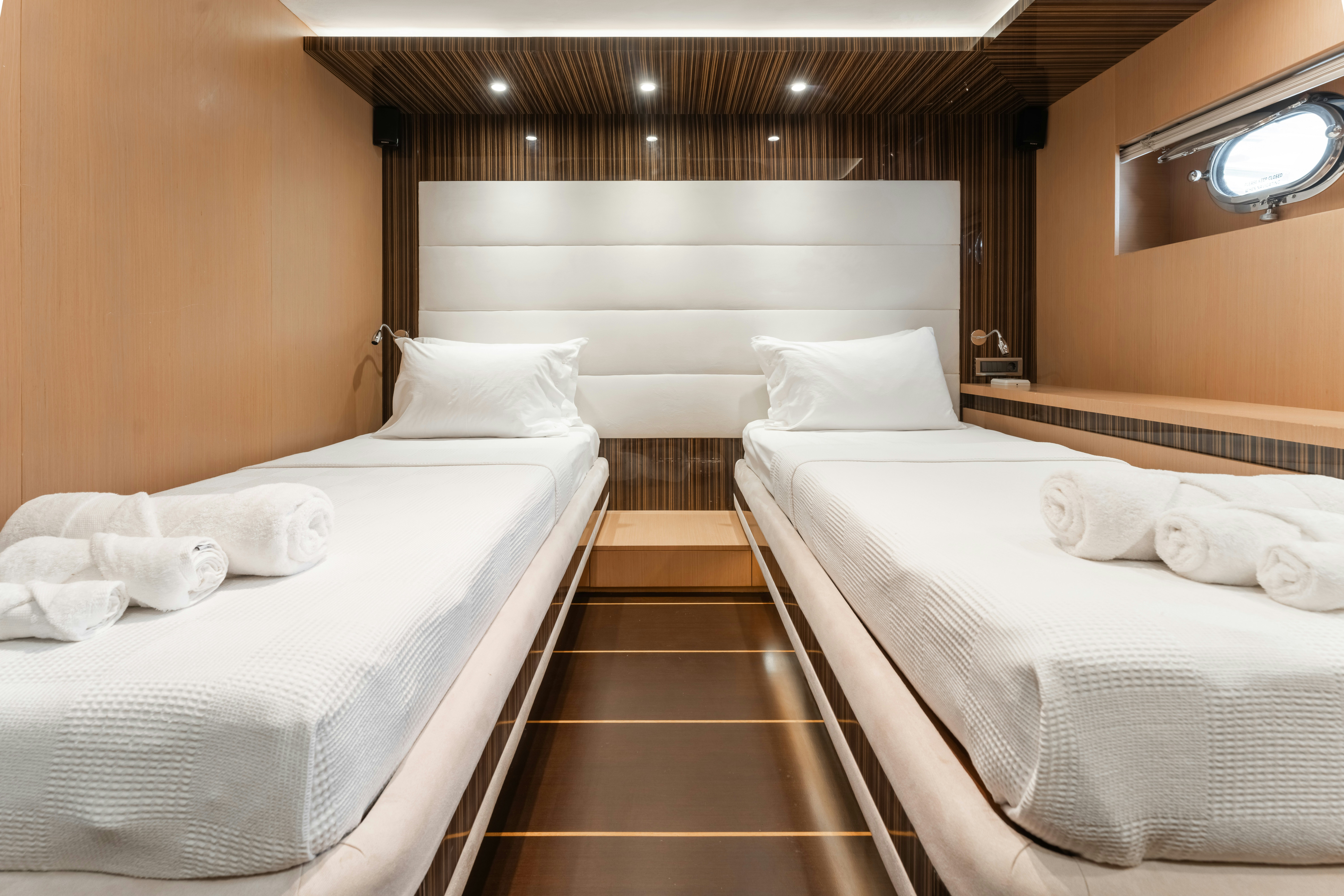 a room with beds and a wood floor aboard LE PIETRE Yacht for Sale