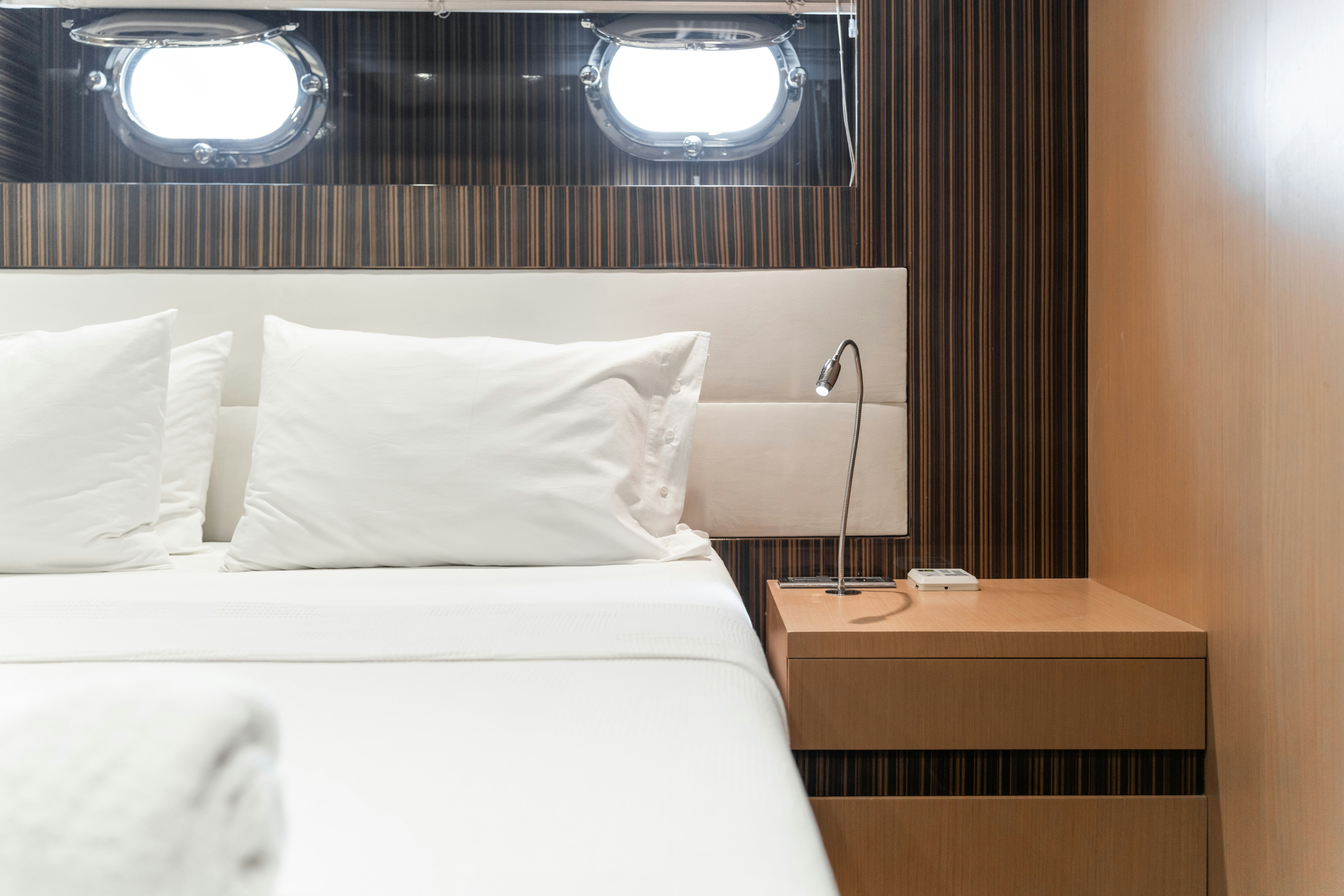 a bed with a white pillow and a white bed spread aboard LE PIETRE Yacht for Sale
