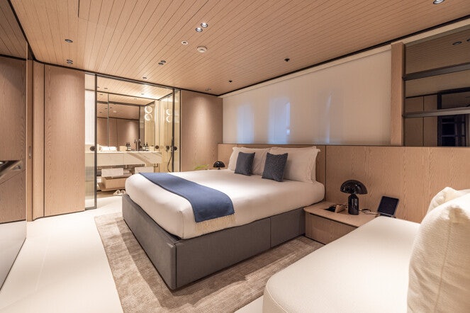 a room with a bed and a desk aboard VIRTUOSITY Yacht for Charter