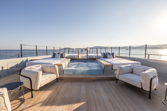 a large pool with a deck overlooking the ocean aboard VIRTUOSITY Yacht for Charter