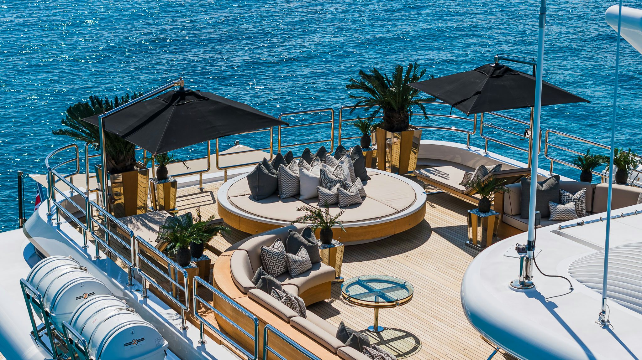 a deck with a lounge chair and umbrellas on it aboard SEALION Yacht for Charter