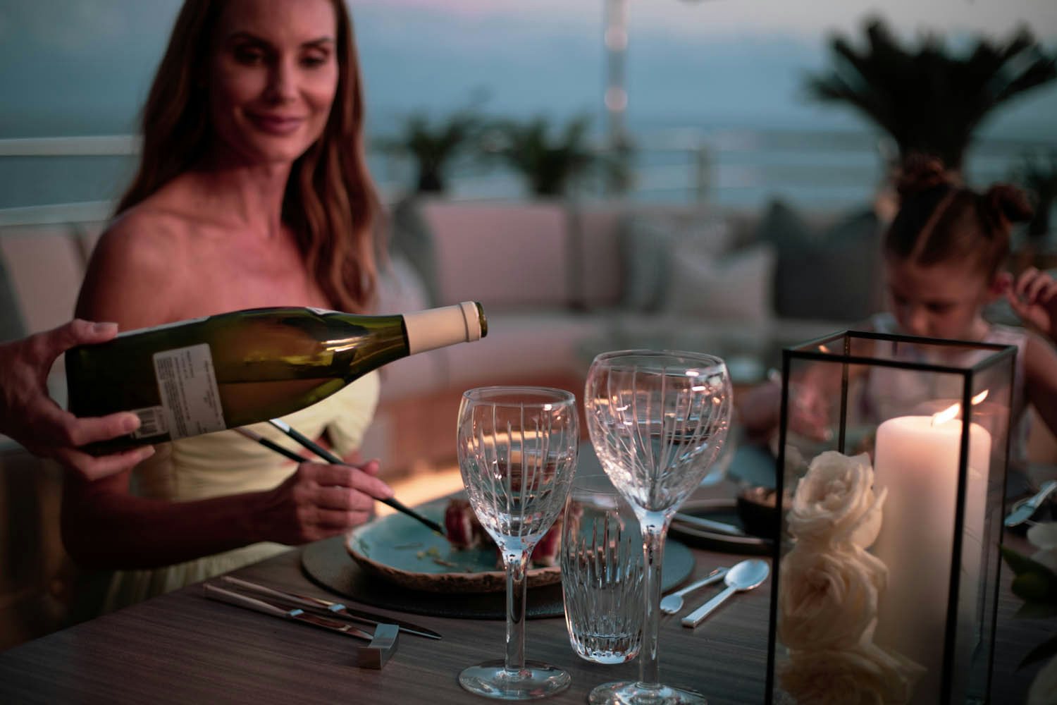 a woman reading a book to a group of people at a table aboard SEALION Yacht for Charter